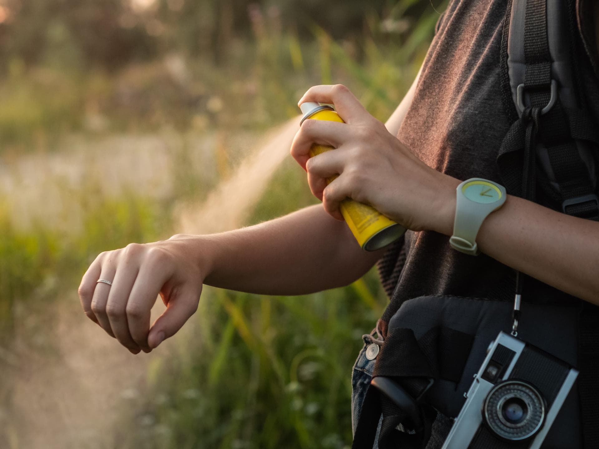 Frau sprüht Spray gegen Mückenstiche Frau sprüht Spray gegen Mückenstiche