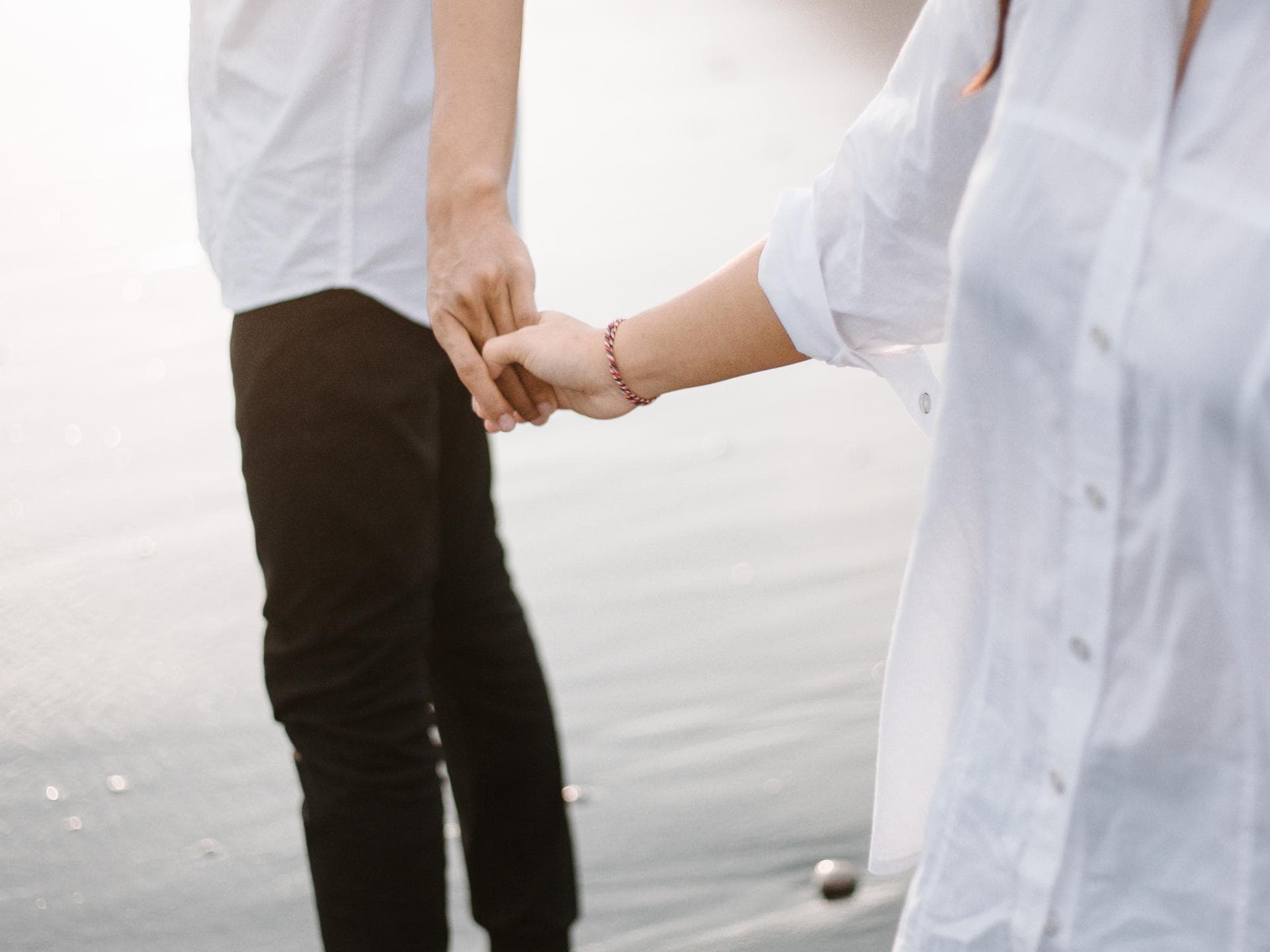 HIV Selbsttest Zuhause Verliebtes Paar am Meer Hand in Hand