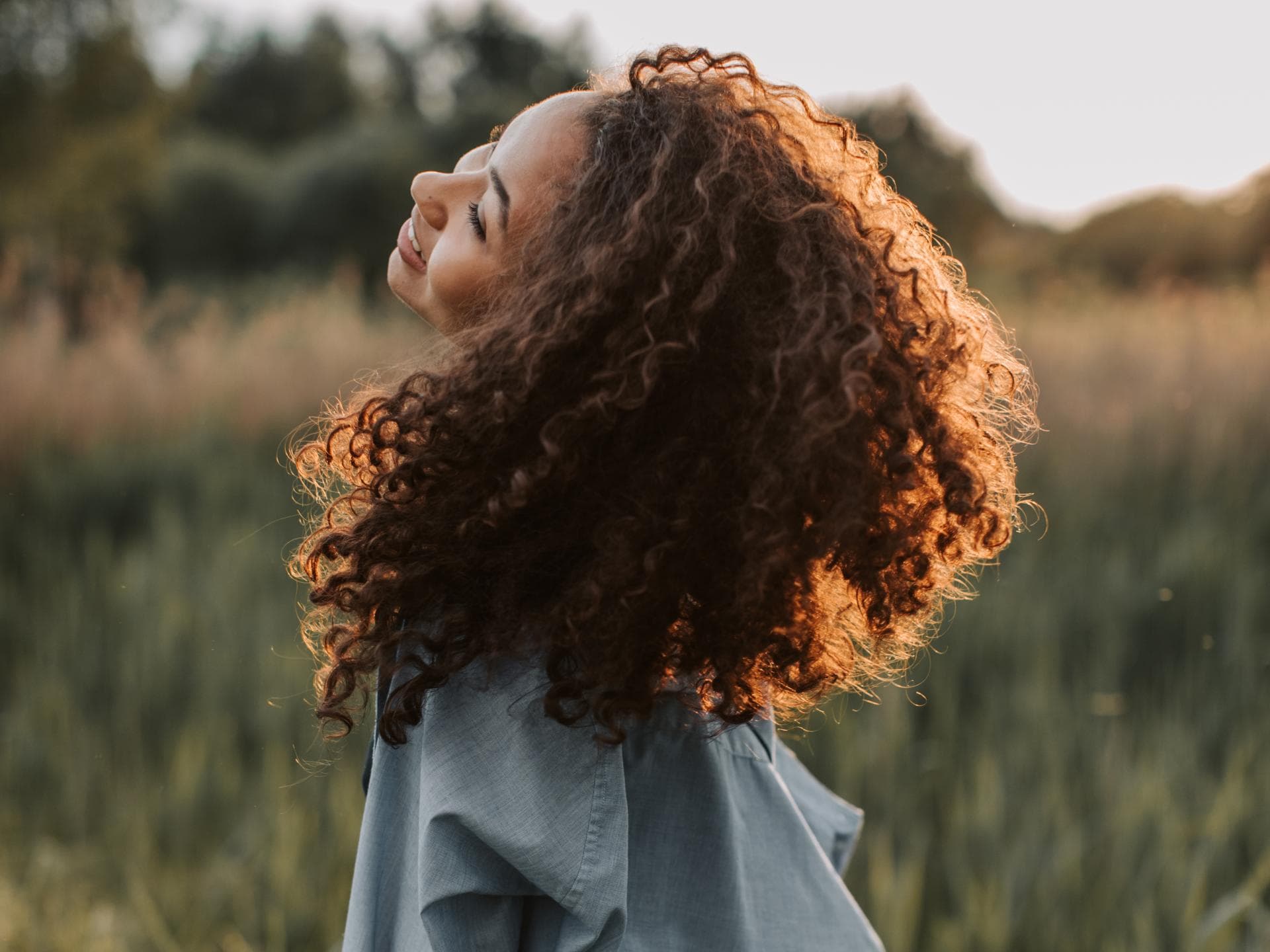 Diese Sternzeichen starten in Leo Season durch Frau steht auf einem Feld und lacht