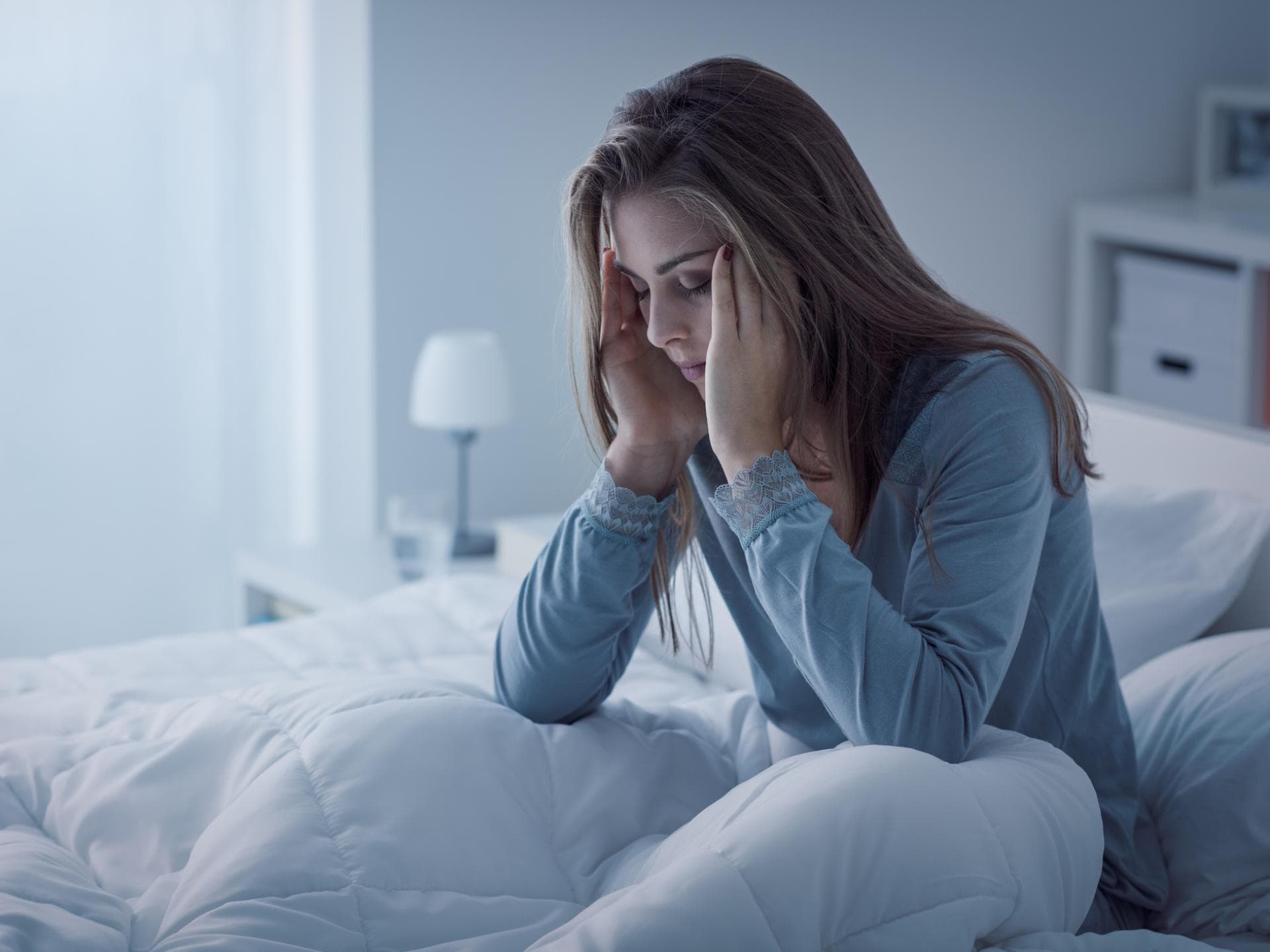 Frau total müde und unausgeschlafen im Bett 