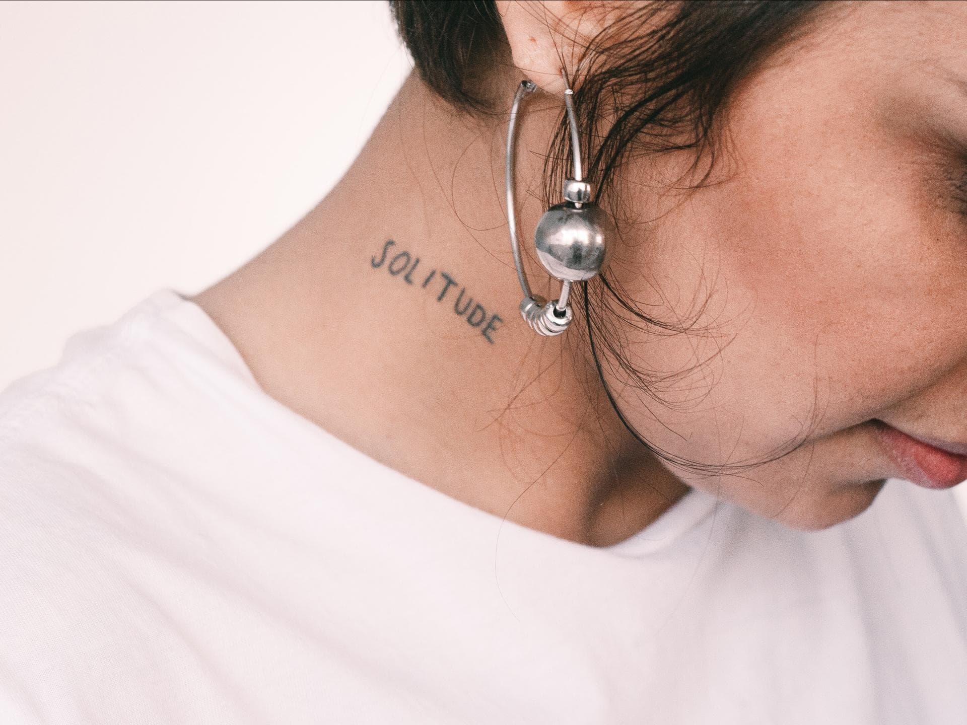 Frau mit einem Tattoo am Hals