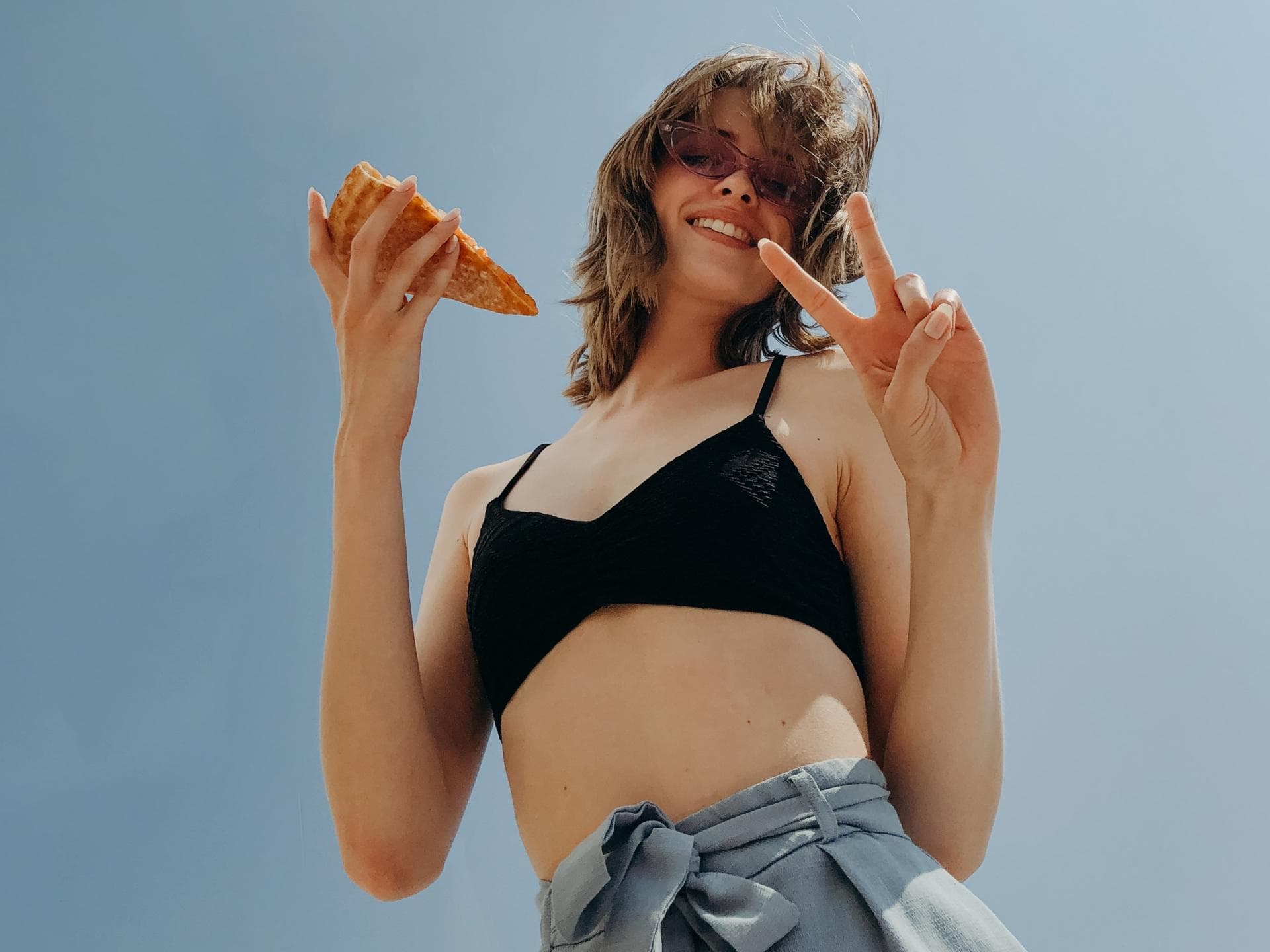 Horoskop Thema Frau mit einem Pizza Stück in der Hand