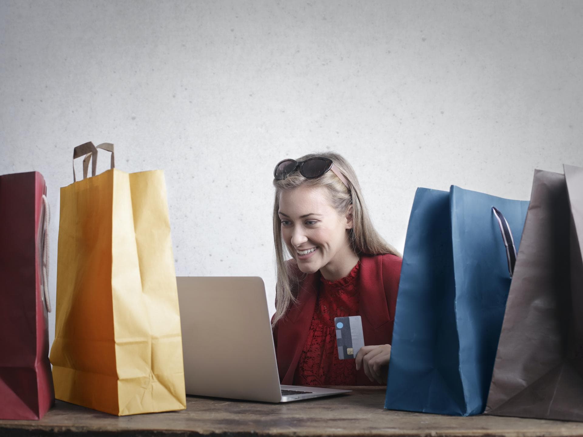 Frau vor Laptop neben Tüten