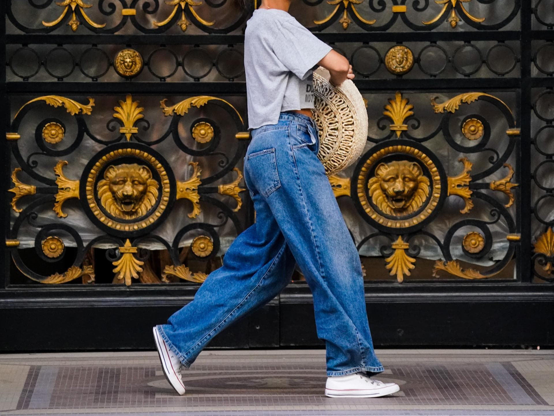 Frau trägt weite Jeanshose und Chucks