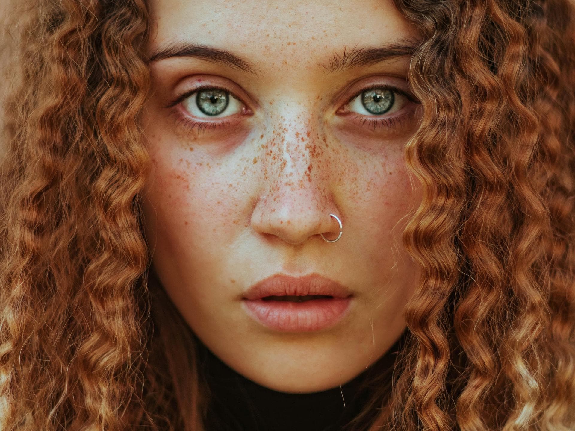 Frau mit roten Locken und Piercing