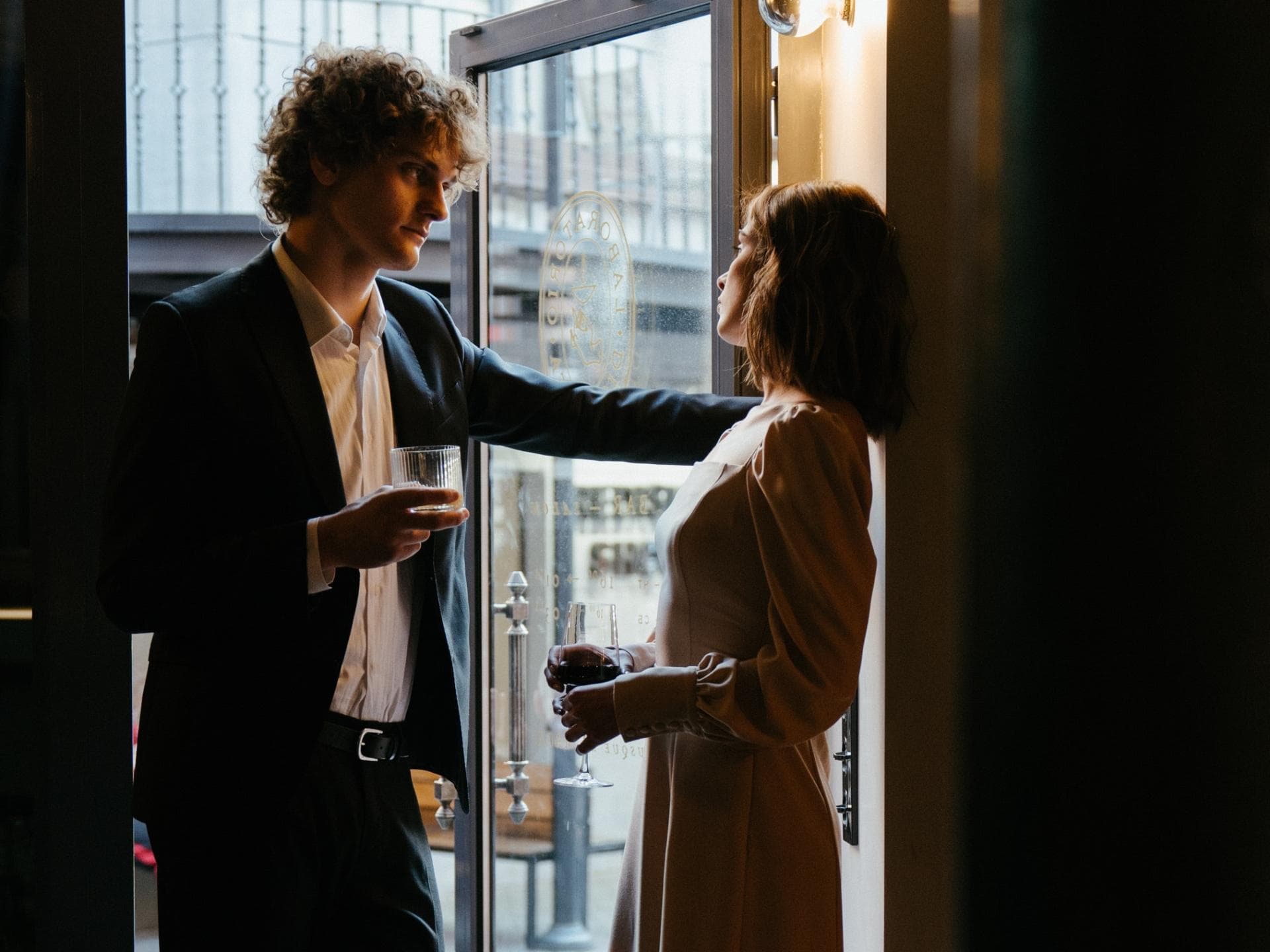 Erstes Date: Er spricht von Ex Erstes Date: Paar steht mit Weingläsern in der Tür
