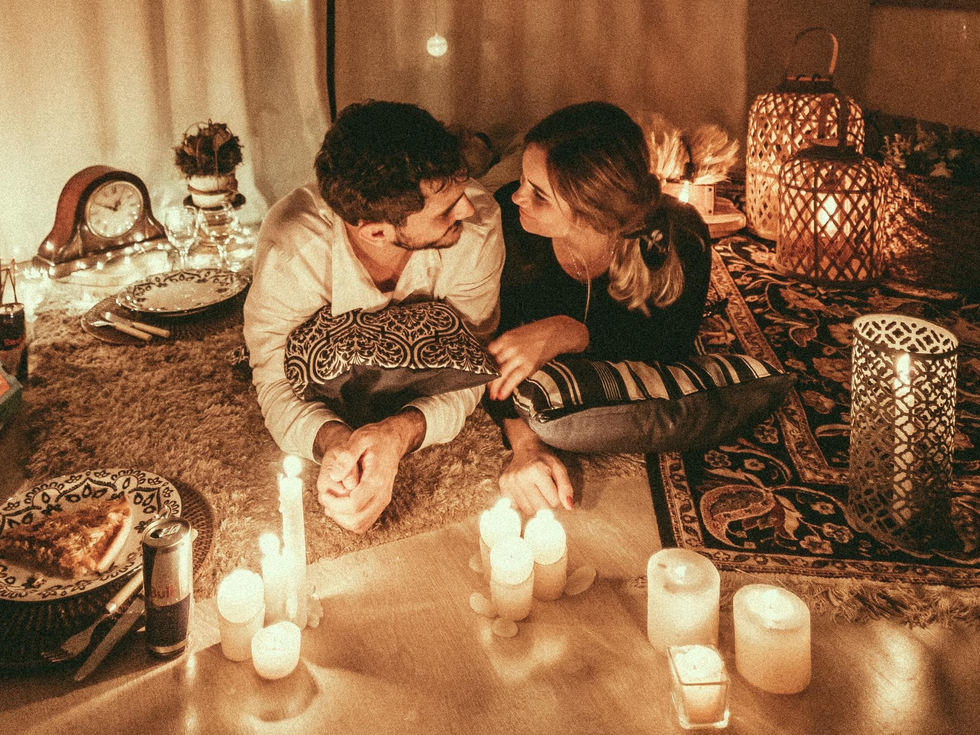 Für diese Sternzeichen wird es im Herbst romantisch Mann und Frau liegen auf Boden zwischen Kerzen