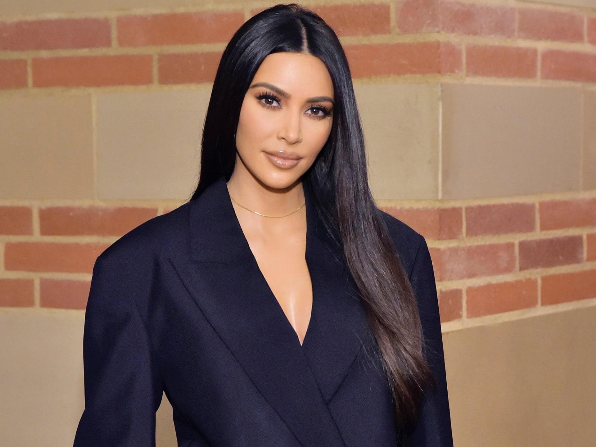 Kim Kardashian in schwarzem Anzug, lange Haare 