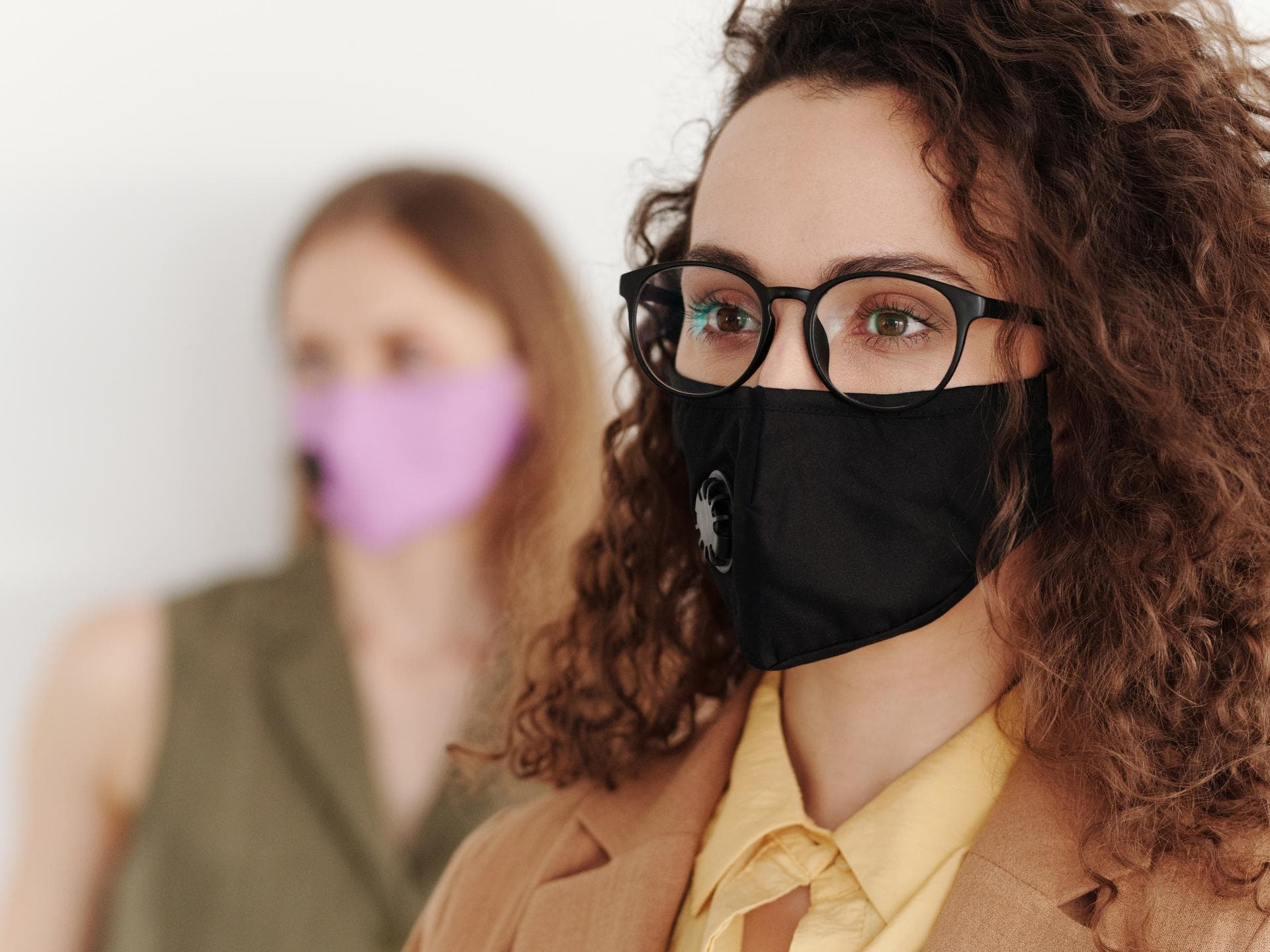 Frau mit schwarzer Brille und Mundschutz
