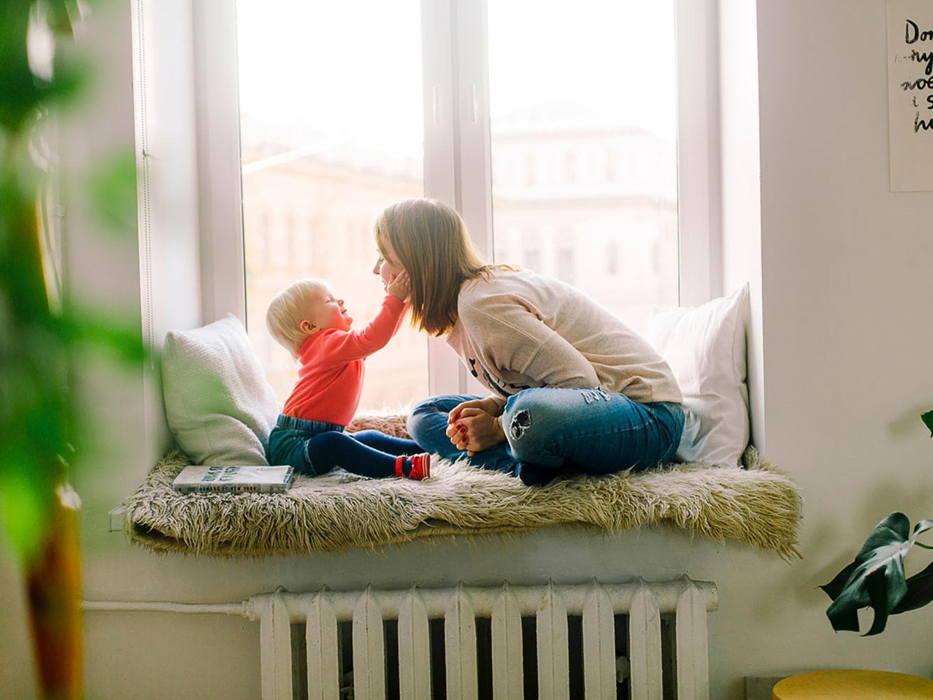 Baby haelt Gesicht von jungen Frau Baby haelt Gesicht von jungen Frau