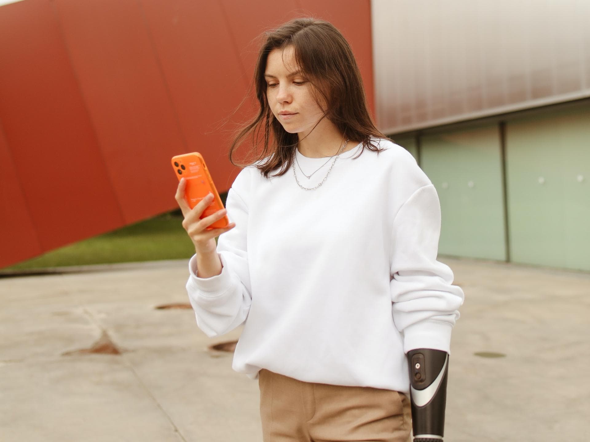 Date Nachrichten: Frau mit Armprothese und Handy in der Hand