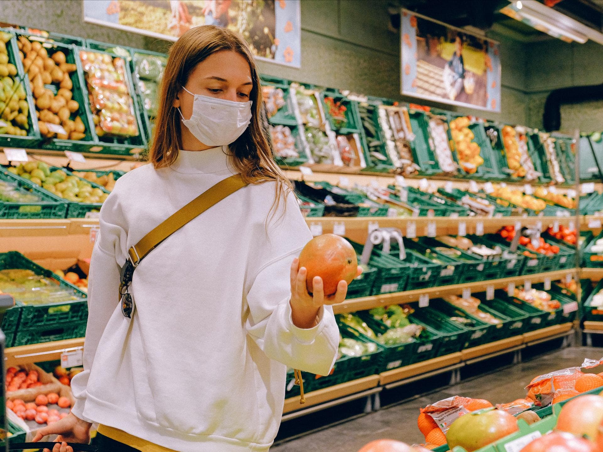Frau im Supermarkt in der Obst- und Gemüseabteilung