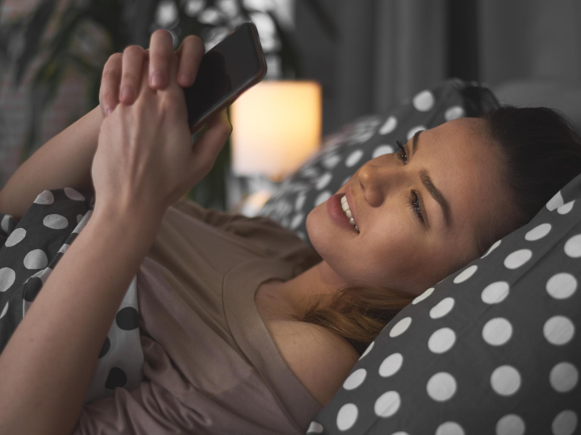 Gute Nacht mein Schatz: Frau liegt in Bett mit Handy