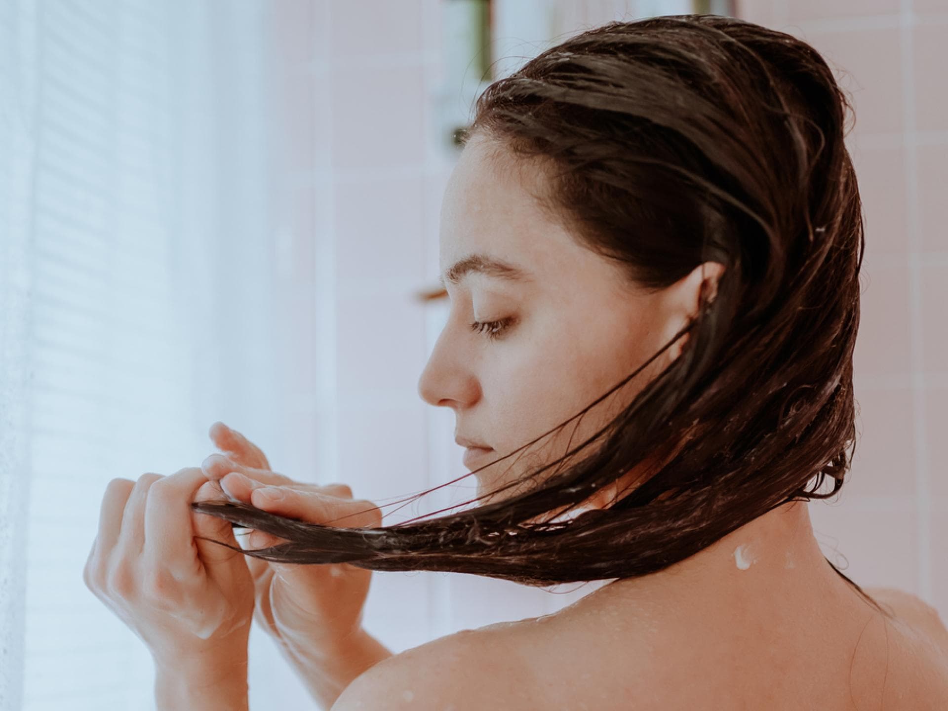 Frau unter der Dusche mit nassen Haaren
