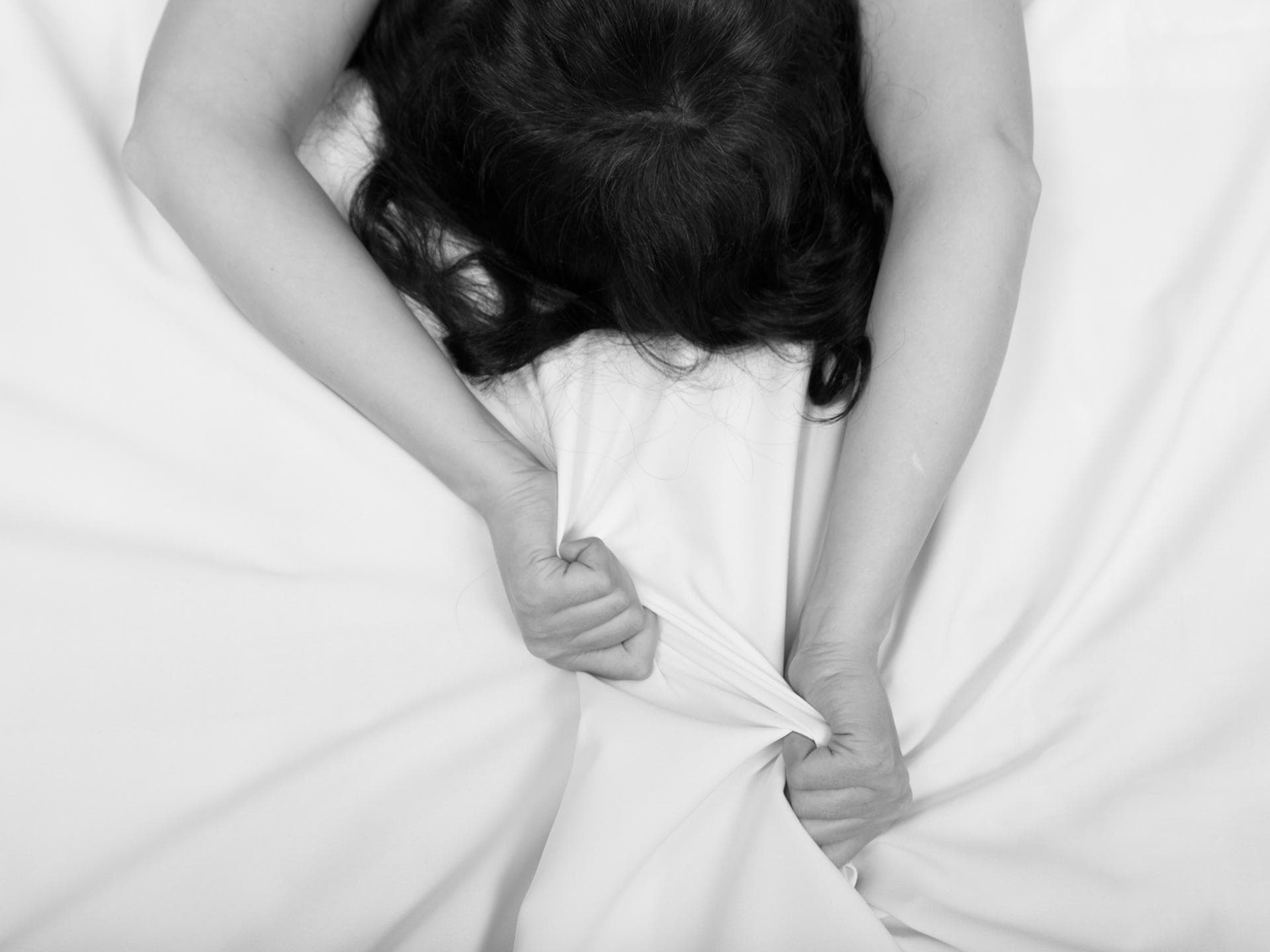 Frau beim Orgasmus im Bett