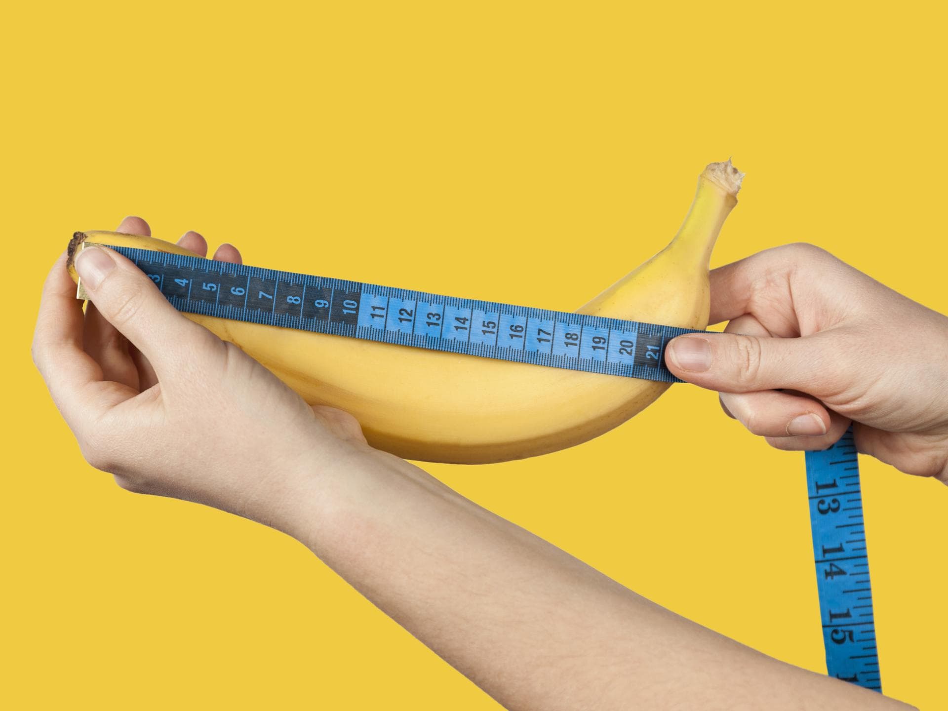 Penisgröße: Was wünschen Frauen? Penisgröße: Hände messen eine Banane mit einem Maßband aus