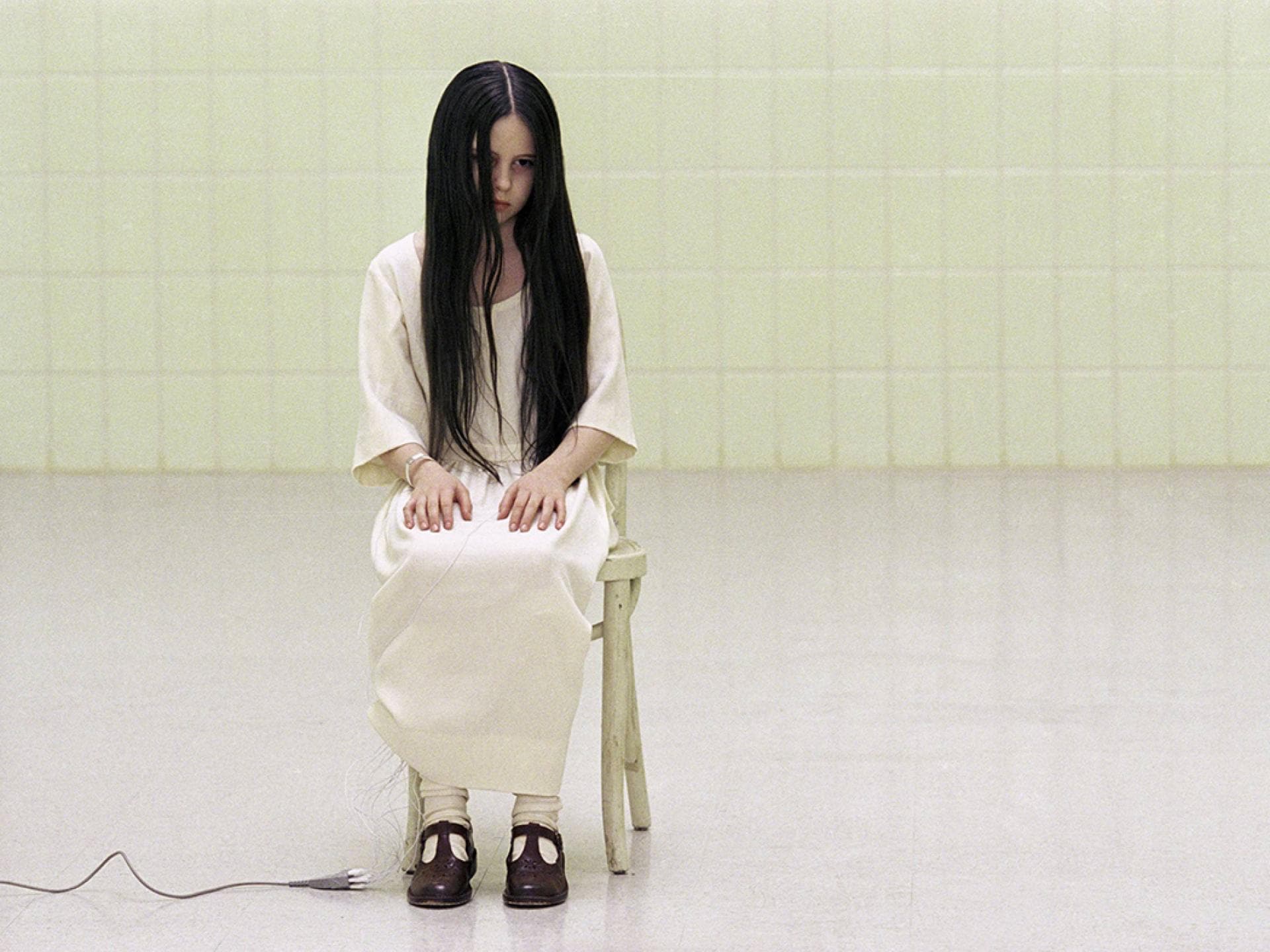 Samara von "The Ring" sitzt auf einem Stuhl