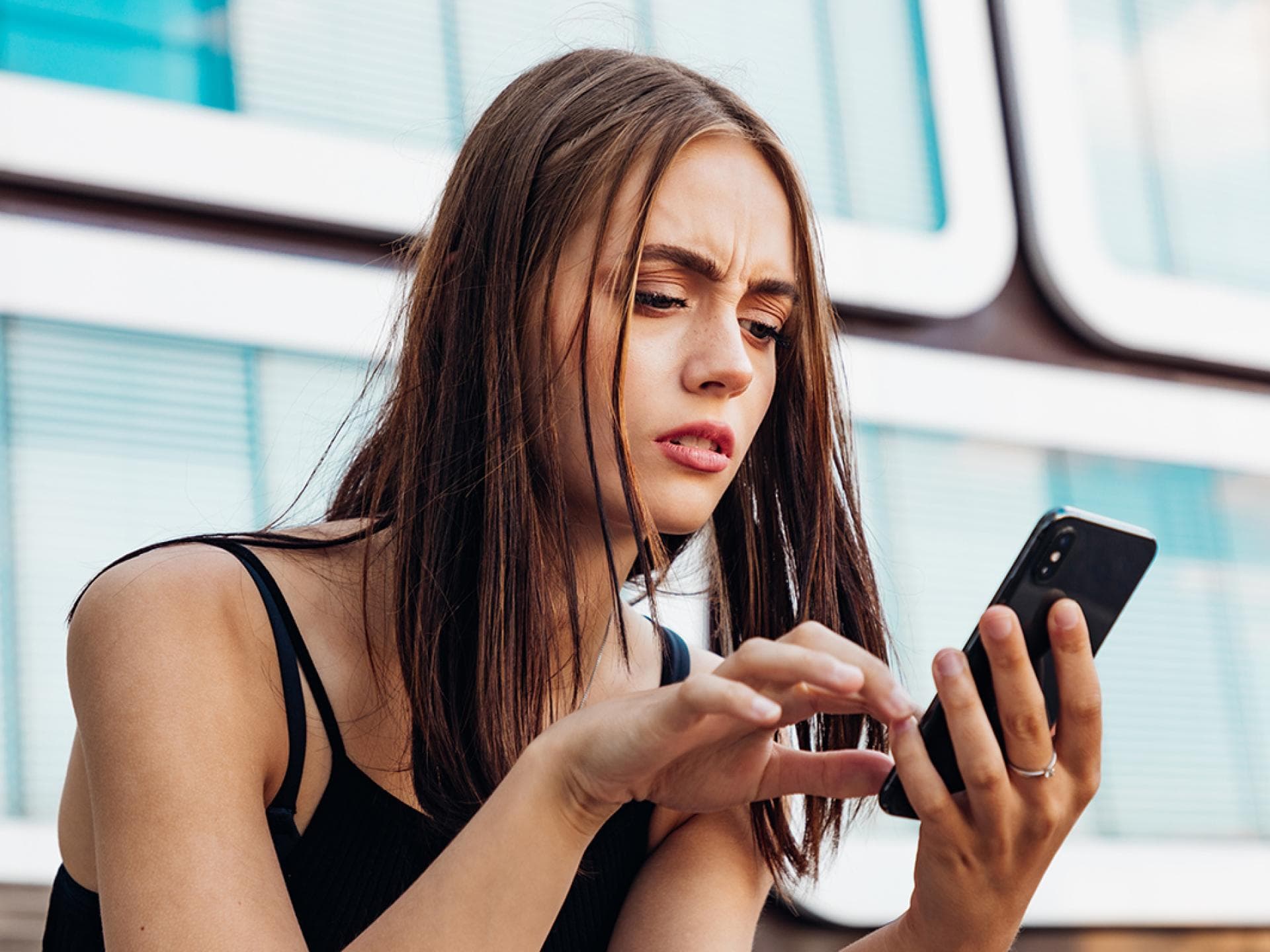 Frau schaut besorgt auf Handy