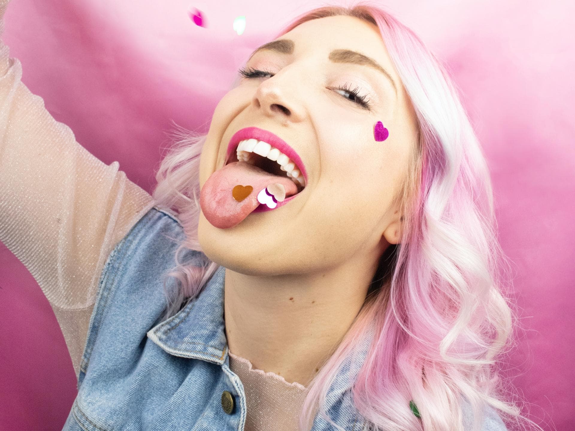 Horoskop: Das Glücks-Sternzeichen des Tages (16. April) Horoskop: Frau mit rosa Haaren und Konfetti im Mund