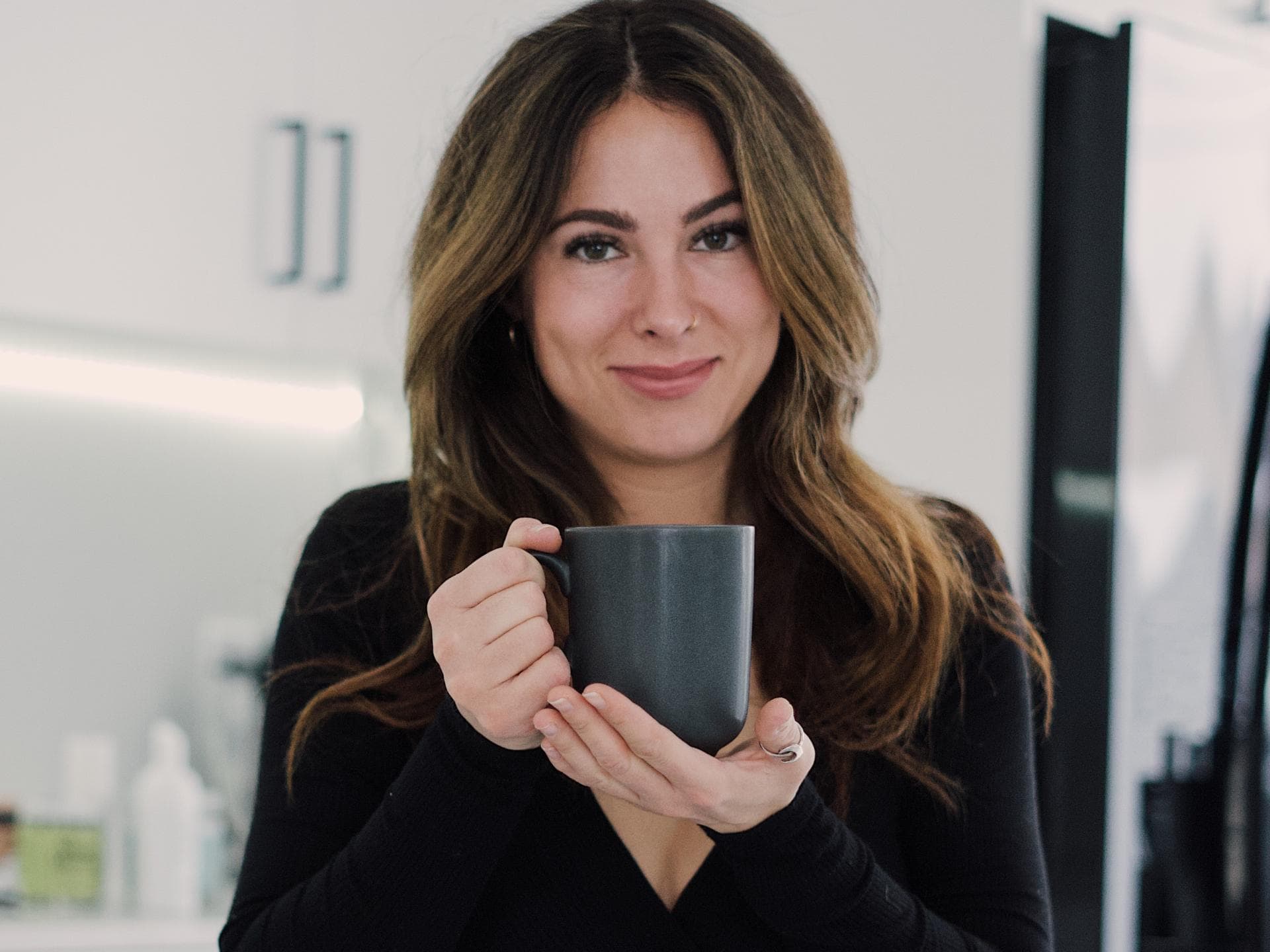 Junge Frau in der Küche mit einer Tasse in der Hand