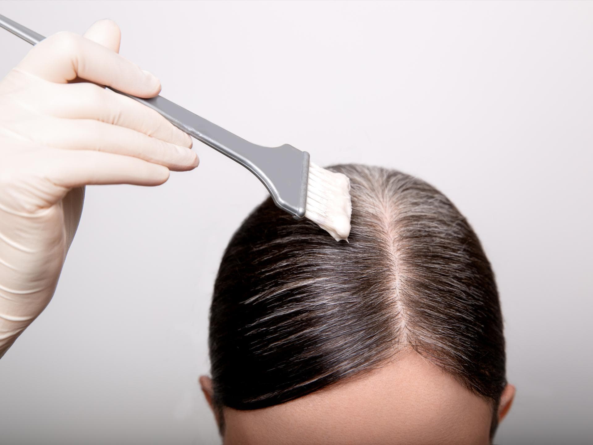 Intensivtönung Der Unterschied zur Tönung Frau mit Haarfarbe und Pinsel