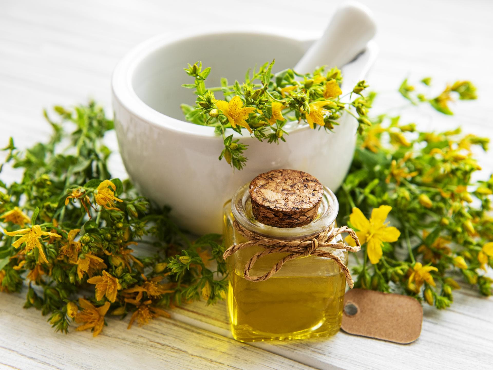 Johanniskrautöl: Flasche mit gelben Blüten