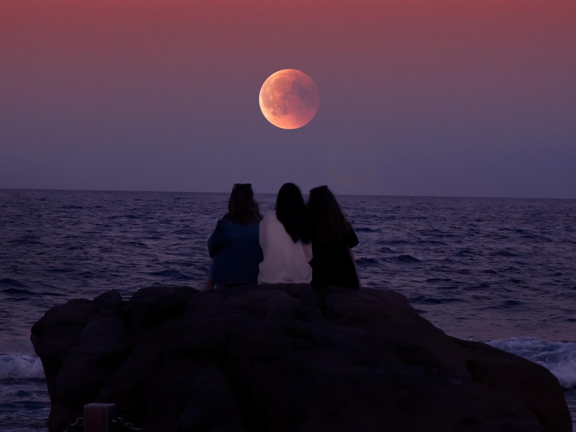 Tageshoroskop für alle Sternzeichen Drei Leute sitzen vor Supermond