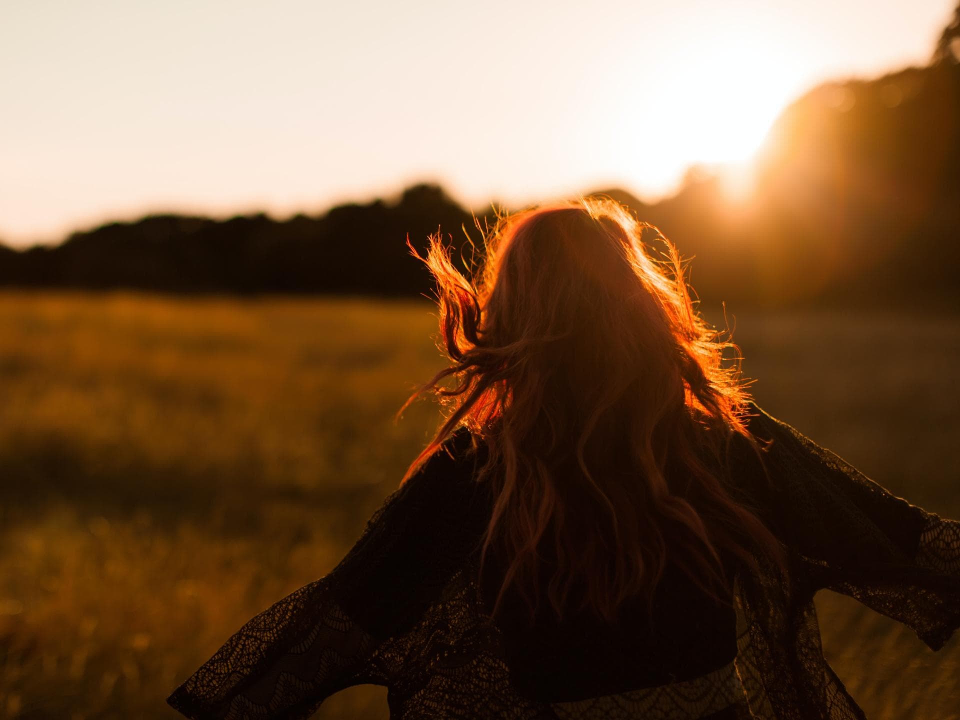 Horoskop: Diese Sternzeichen brauchen jetzt ihren Freiraum Horoskop: Frau läuft auf Feld mit offenen Armen
