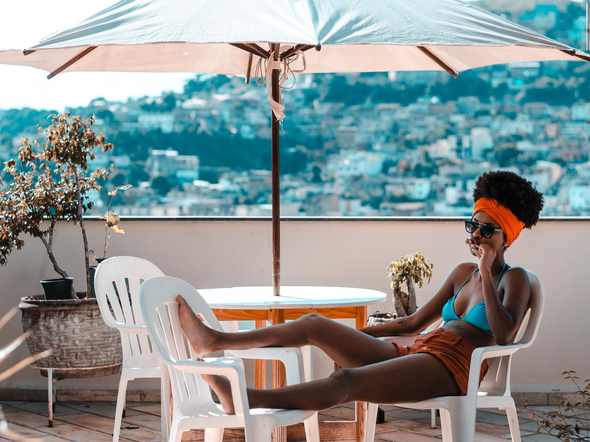 Coronavirus Urlaub Reisen möglich? Frau liegt auf dem Balkon im Bikini