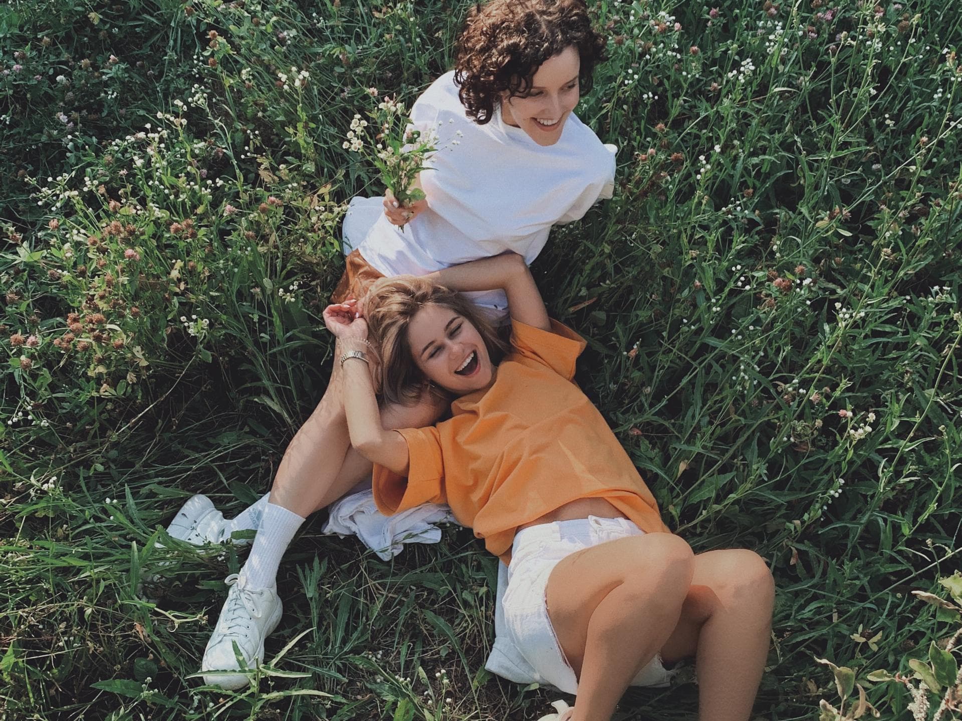 Horoskop der Woche: Zwei Frauen liegen in einem Feld