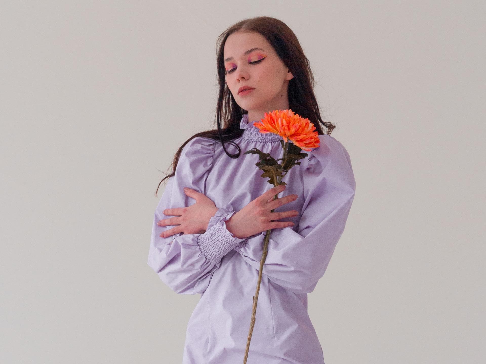 Horoskop Thema: Frau im lilafarbenen Kleid mit Blume