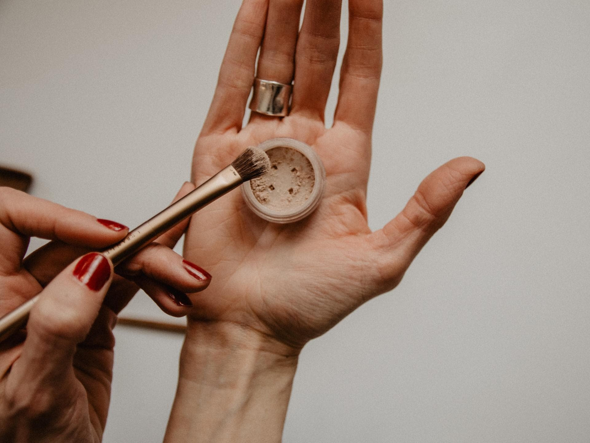 Hand hält Make up Puder und Pinsel Hand hält Make up Puder und Pinsel