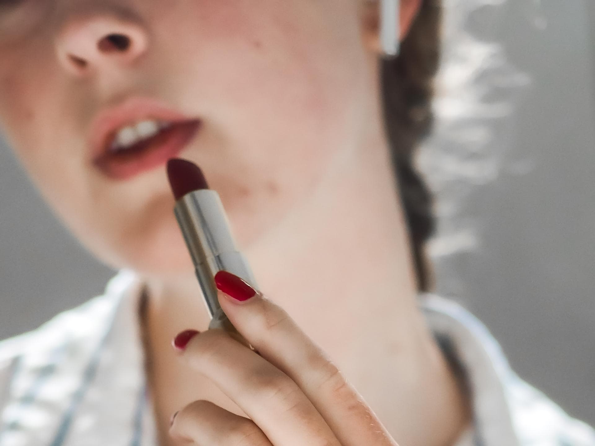 Lippenstift auftragen rote Fingernägel