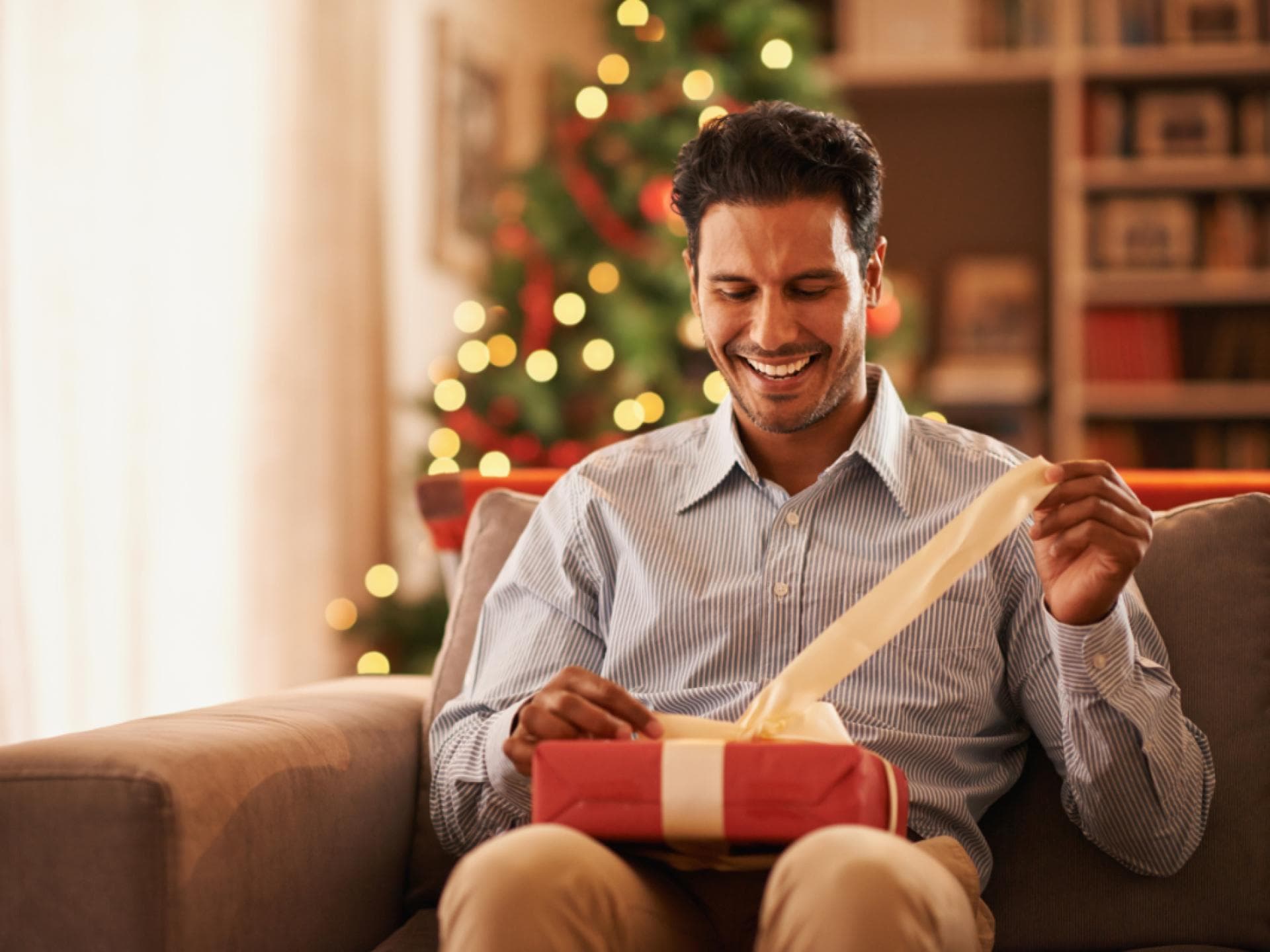 Mann öffnet ein Weihnachtsgeschenk