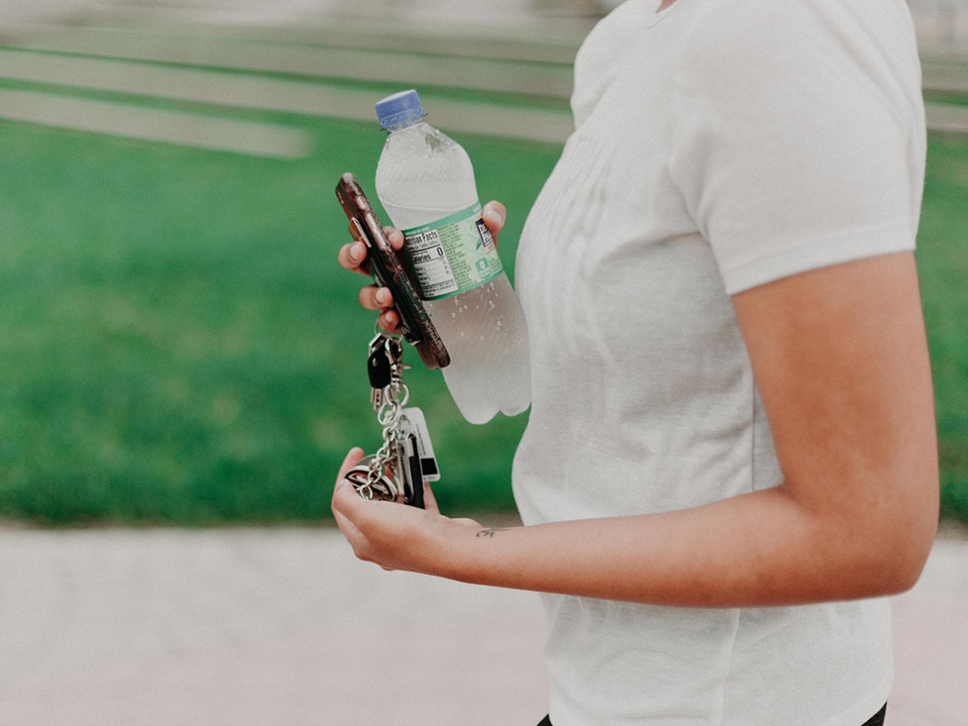 Frau hält eine Wasserflasche und Schlüssel