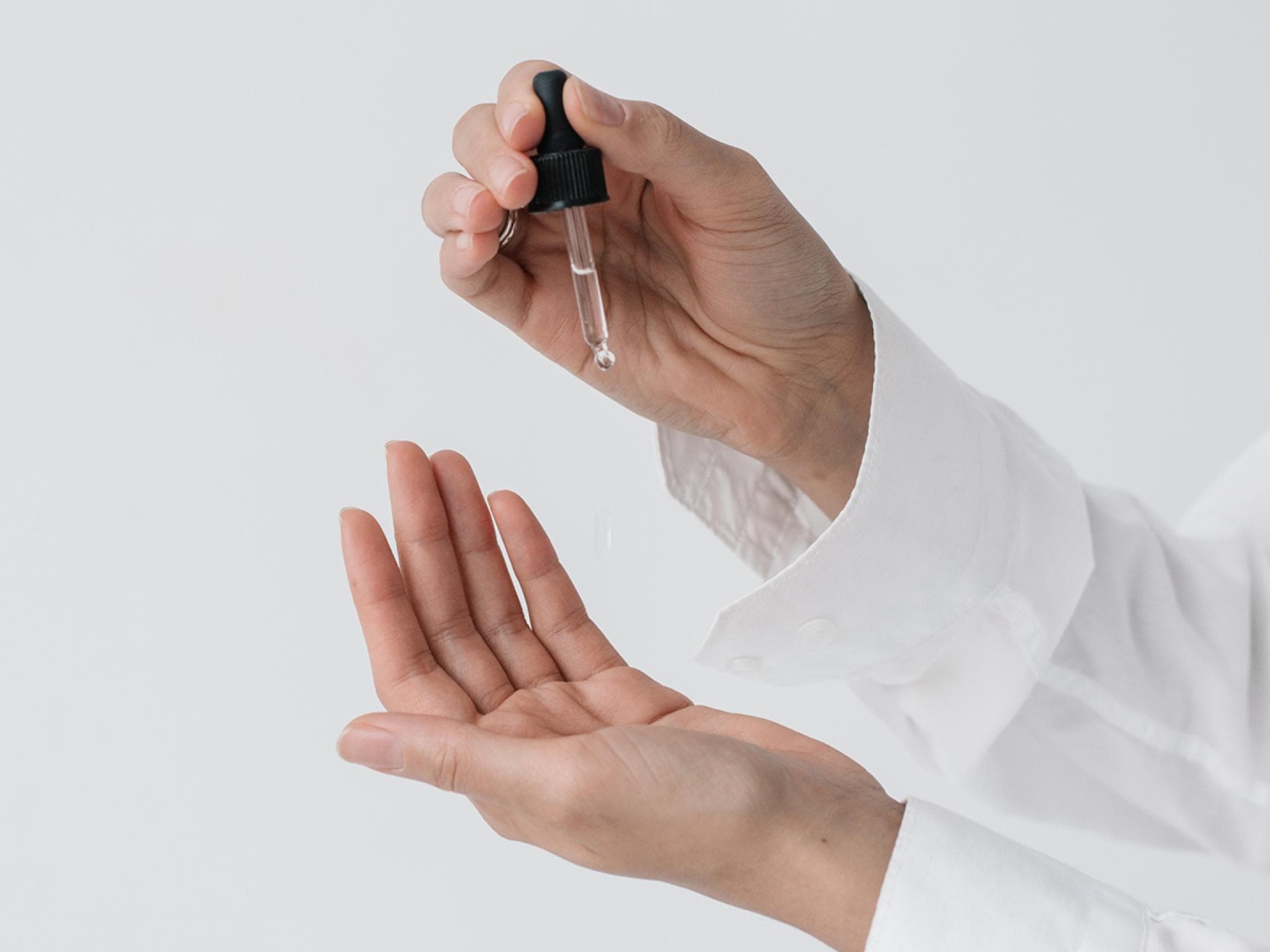 Hände mit Pipette in der Hand