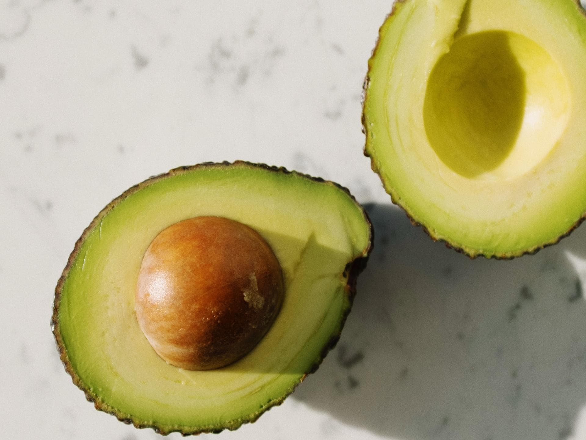 Avocadohälften auf Marmortisch
