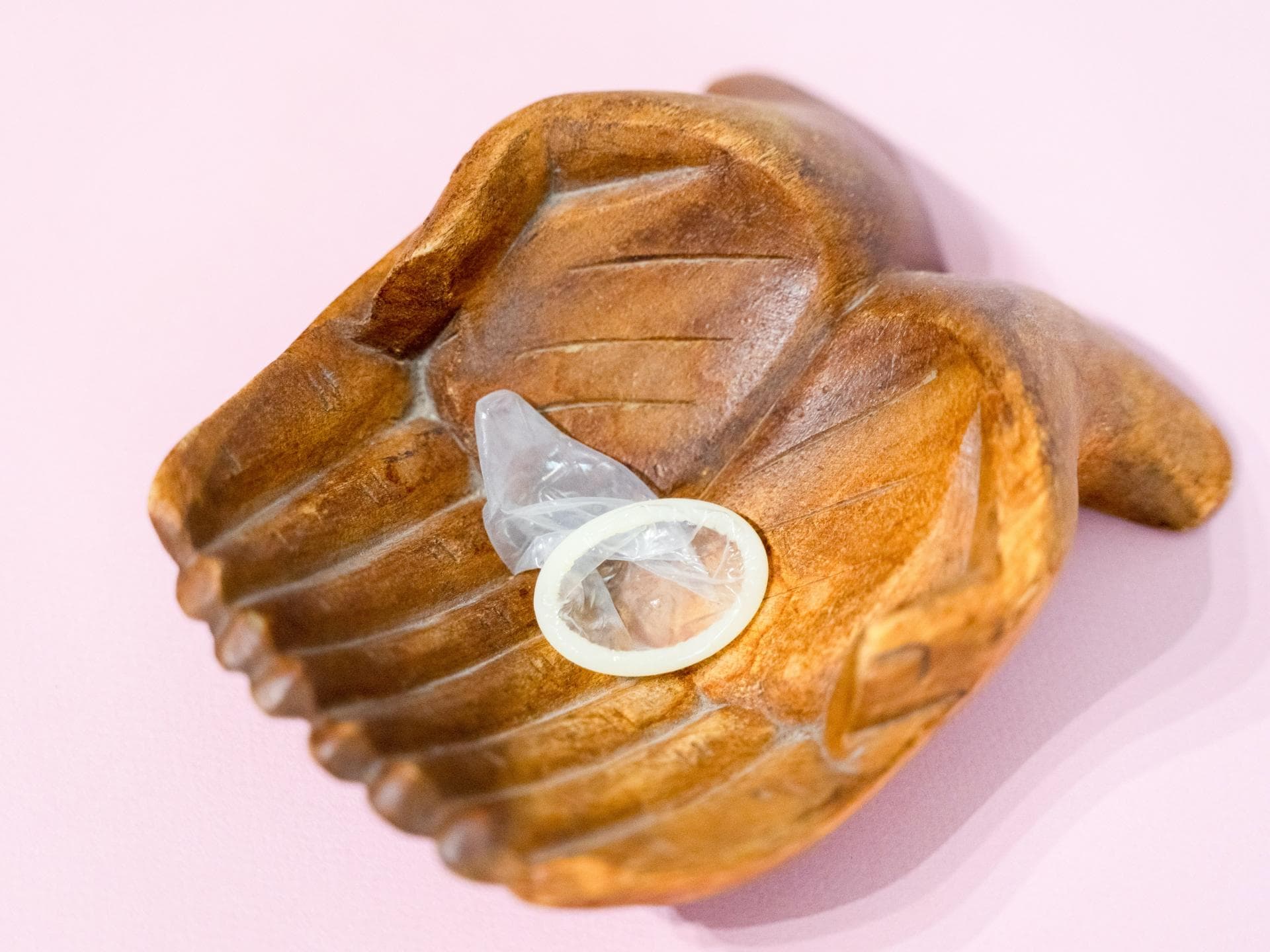 Veganes Kondom in Holzschale