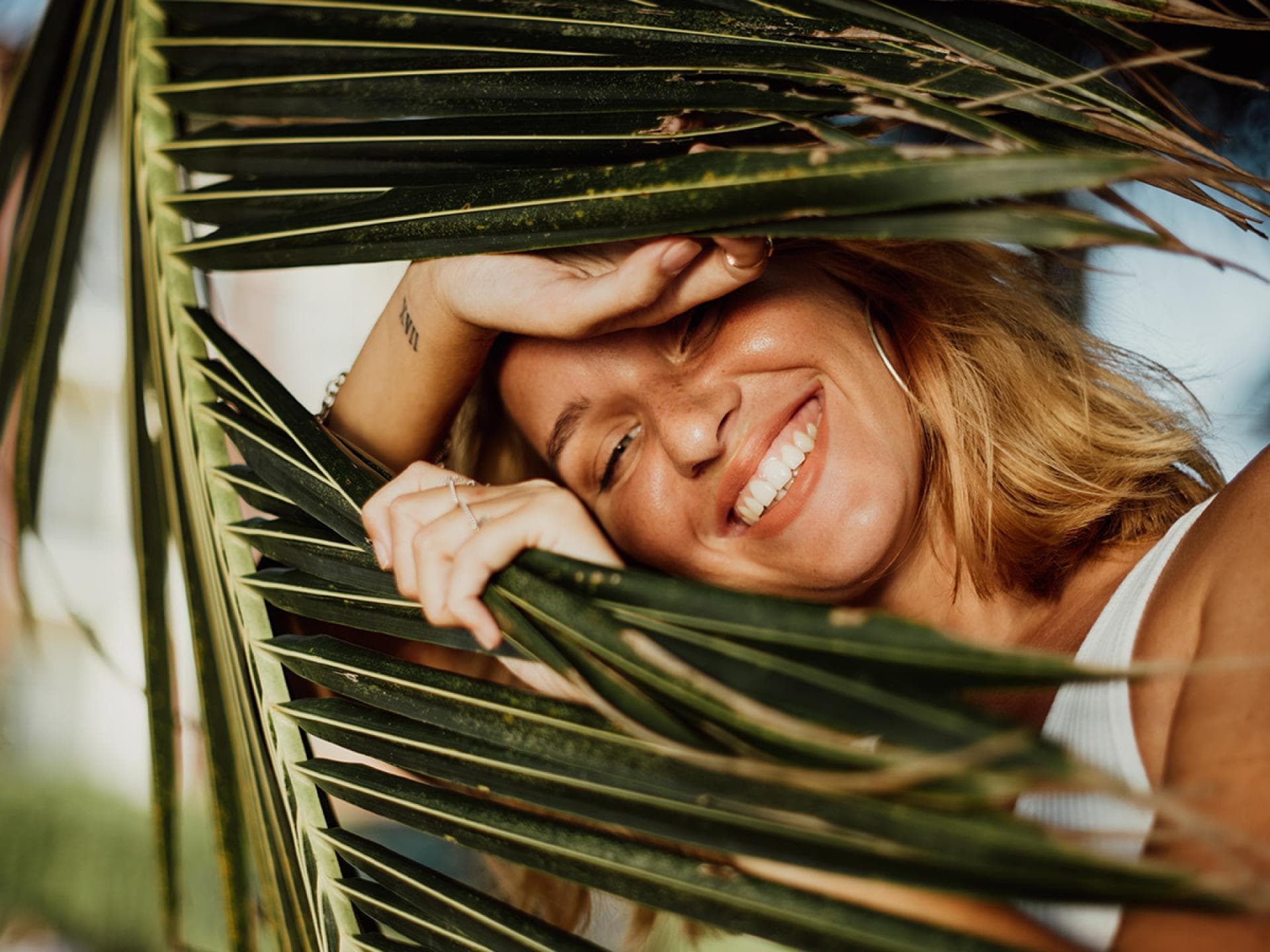 Frau schaut durch Palme