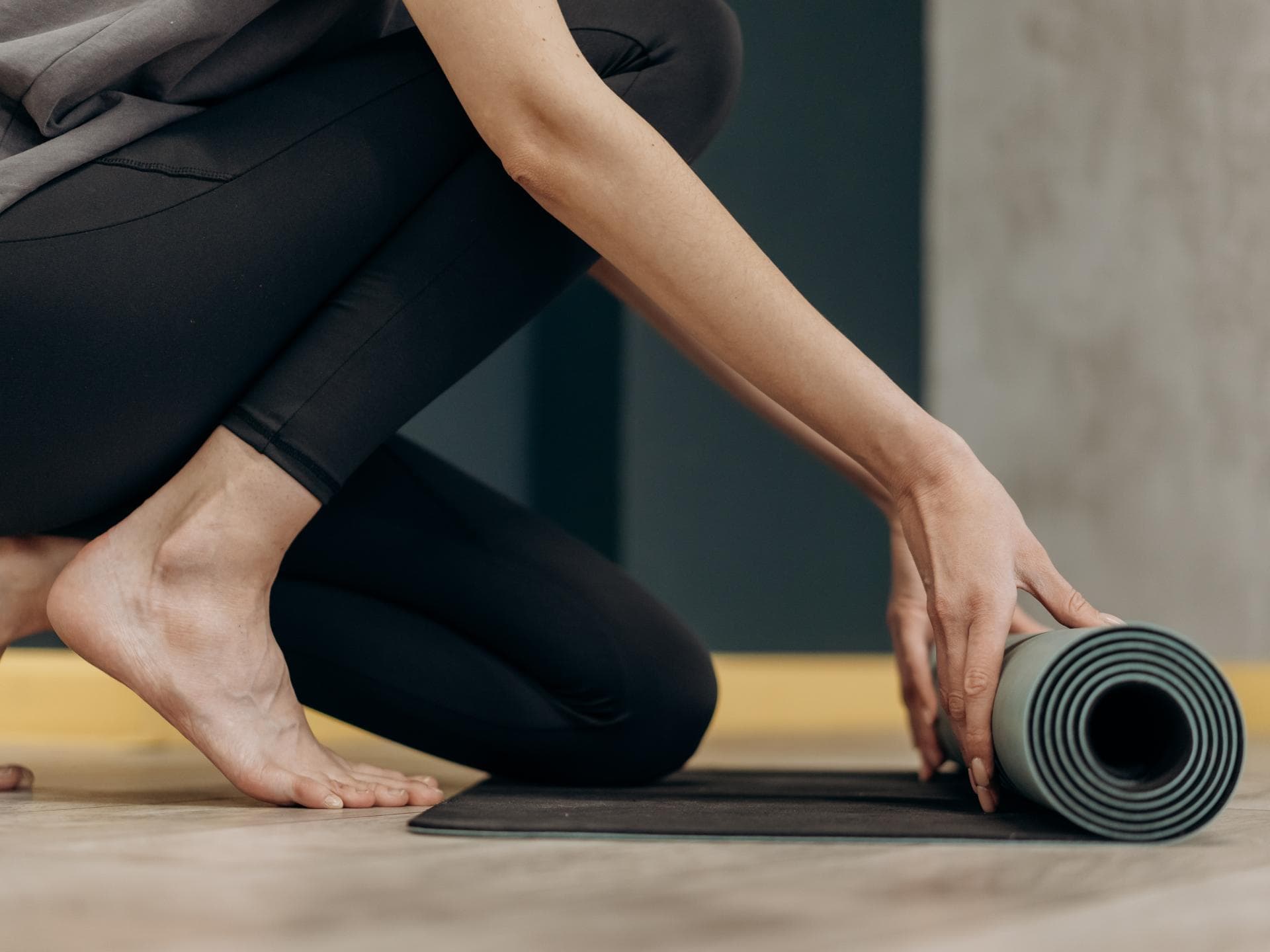 Frau rollt Yoga Matte aus