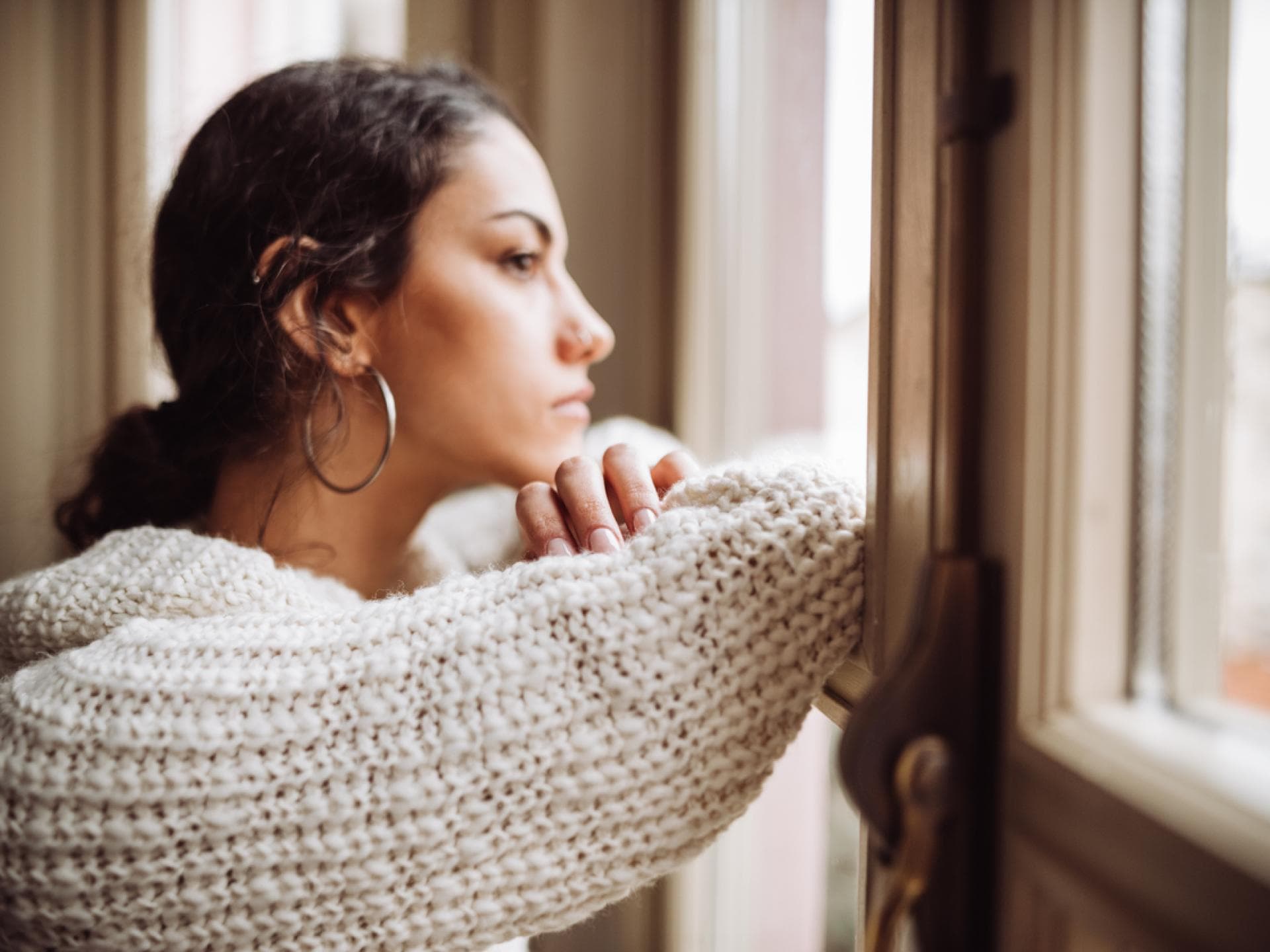 Unglückliche Frau schaut aus dem Fenster
