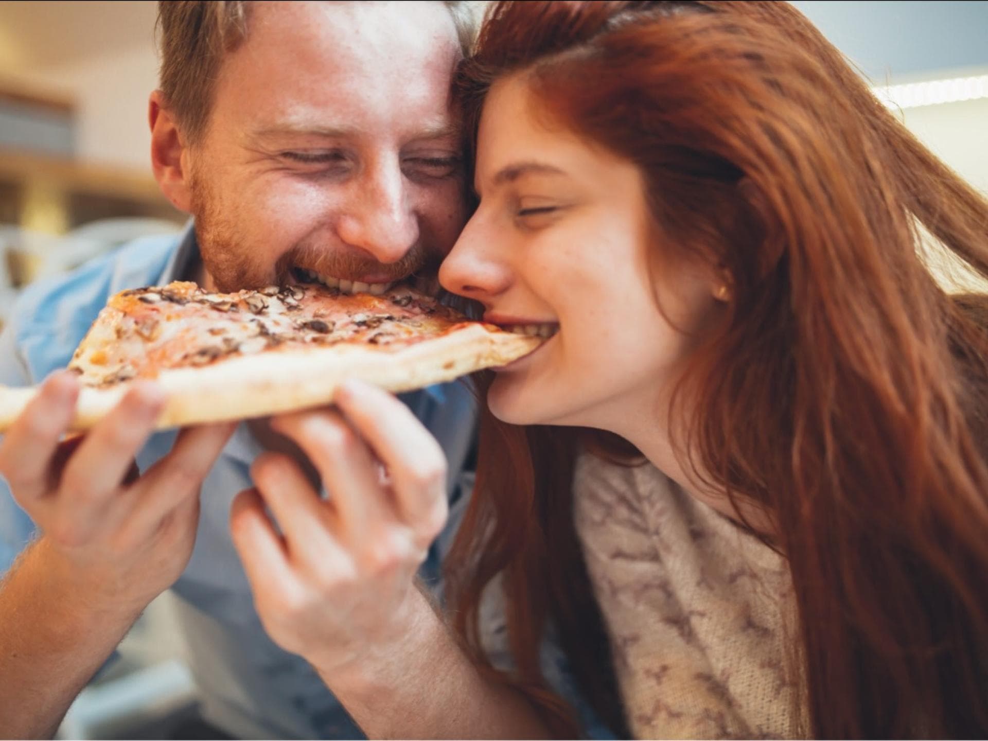 Mann und Frau teilen sich eine Pizza