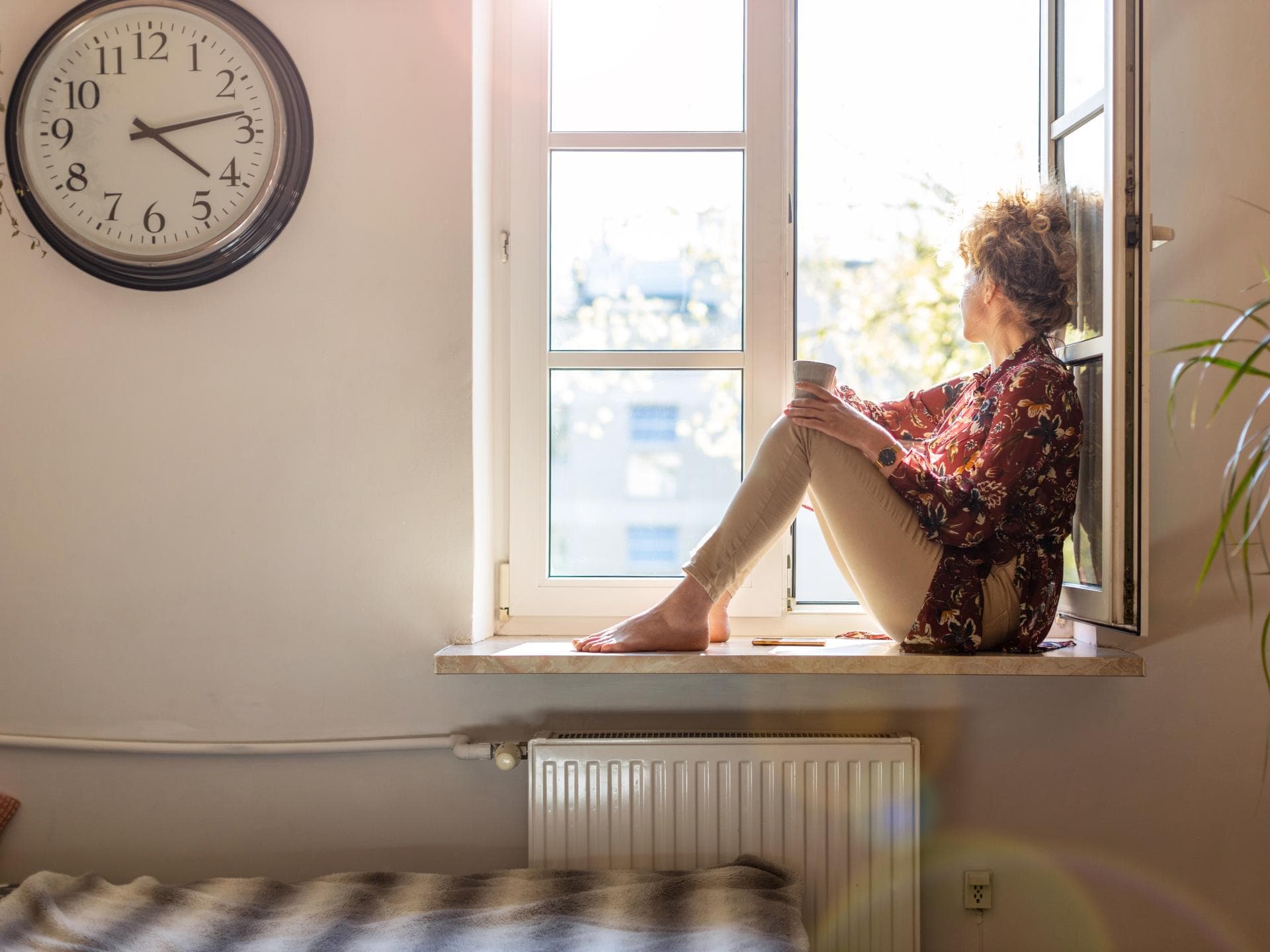 Frau sitzt alleine am Fenster