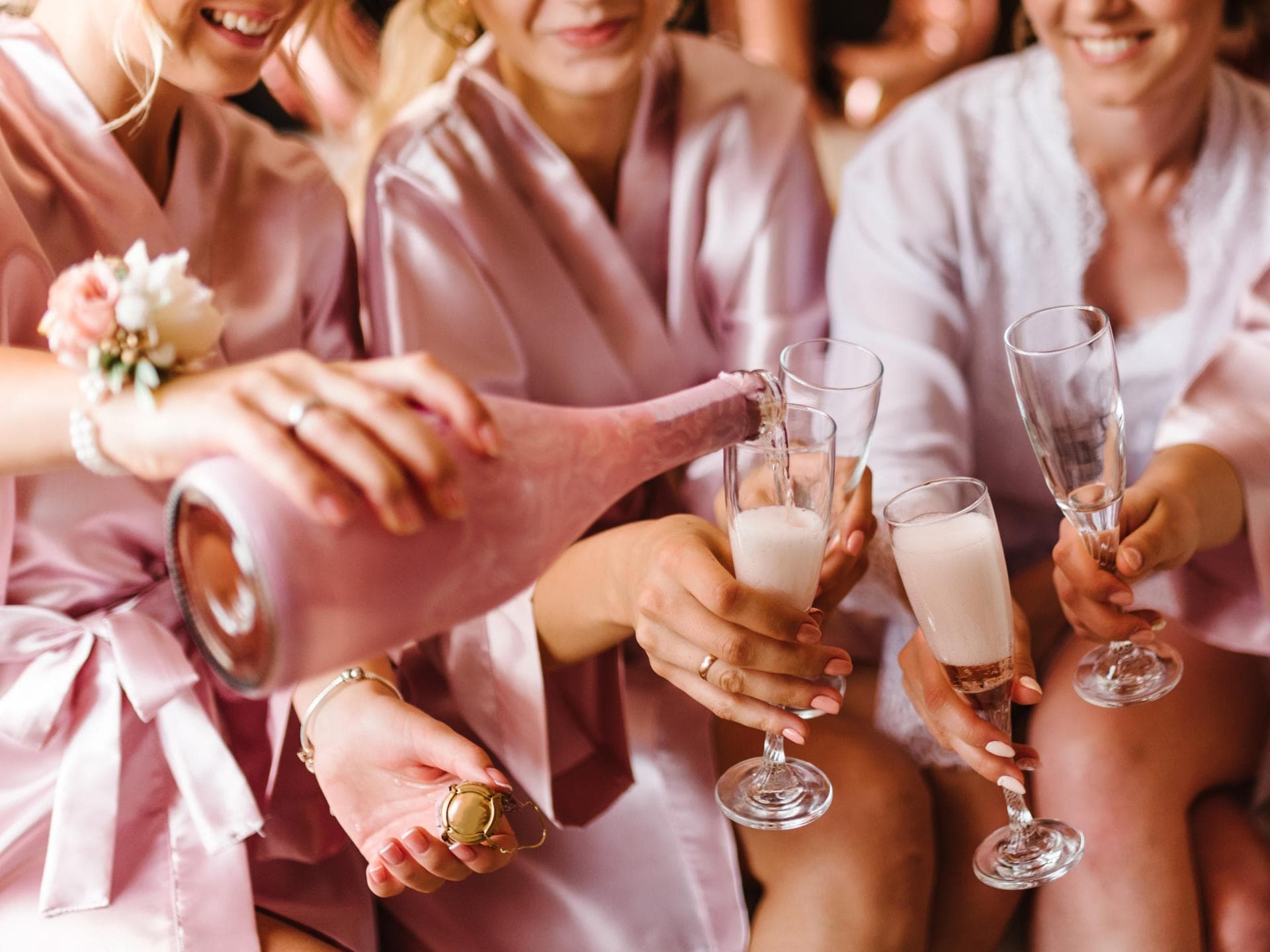 Trauzeuginnen stoßen im pinken Pyjama mit Champagner an 