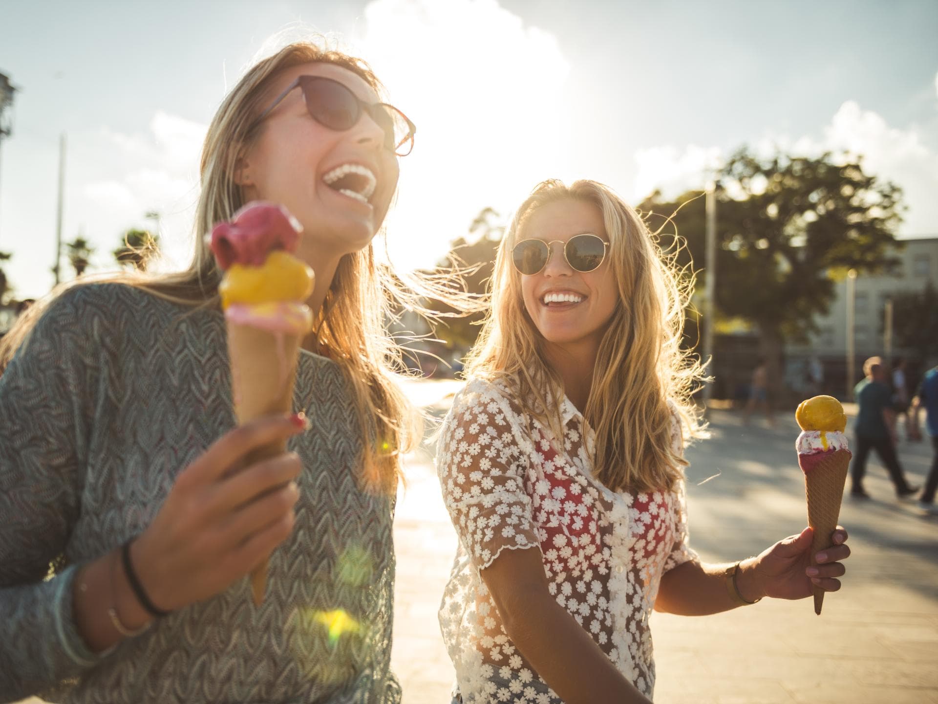 Zwei Freundinnen lachen gemeinsam und essen Eis 