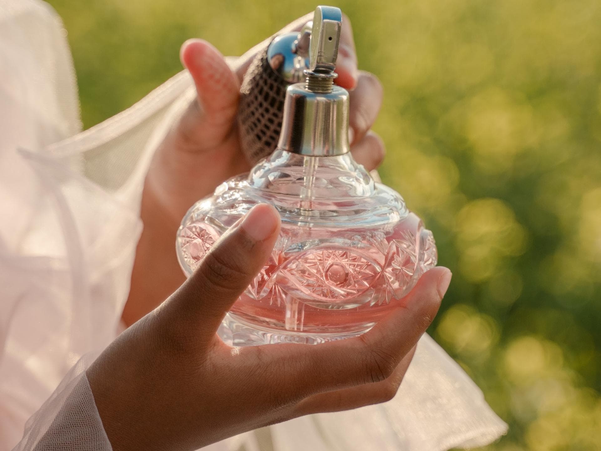 Frau mit Parfum Flakon in der Hand