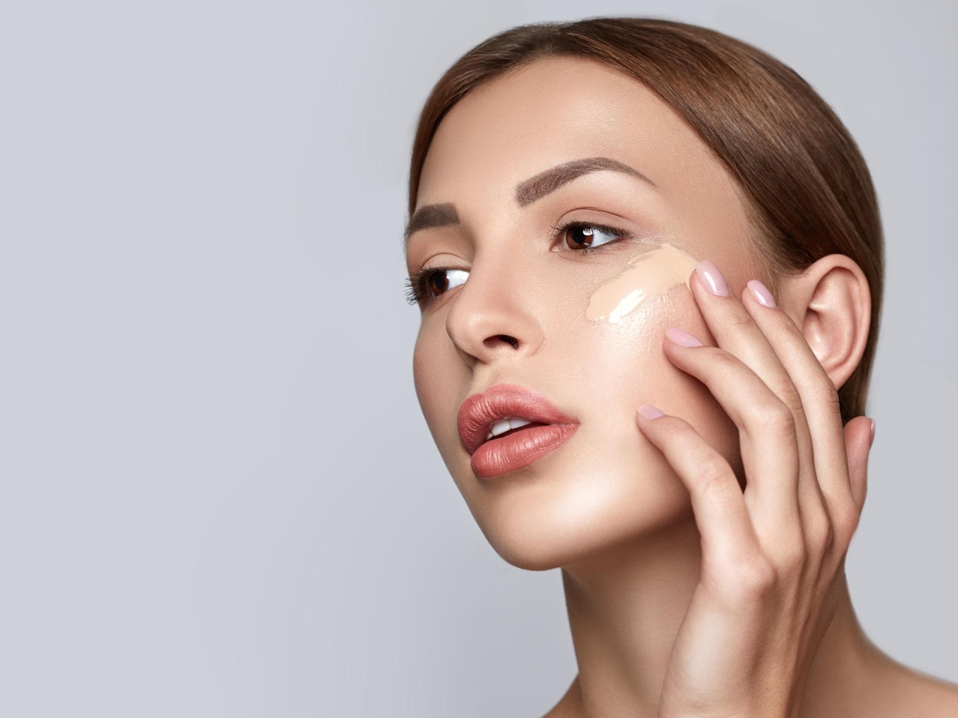 Frau trägt BB Cream im Gesicht auf