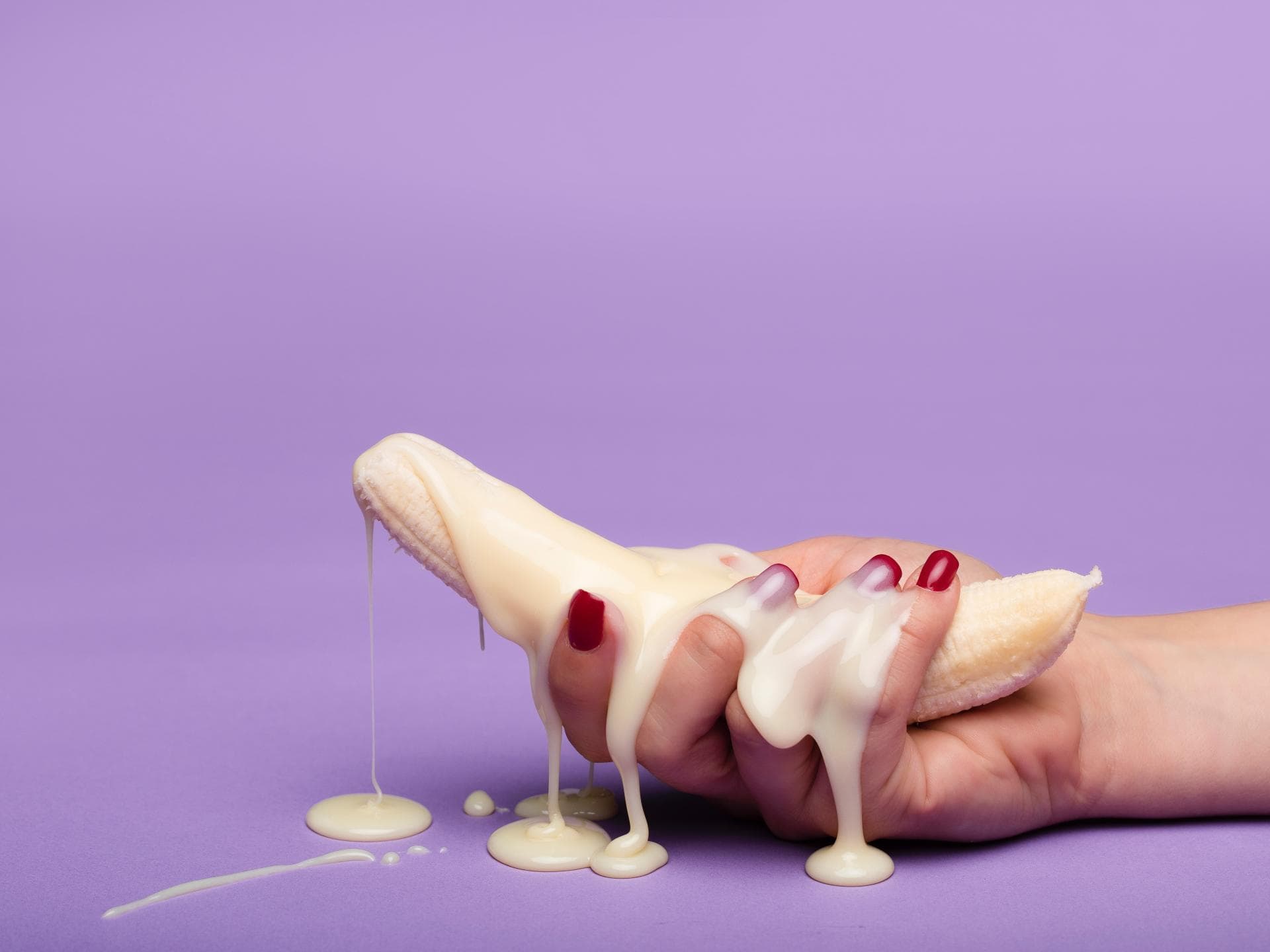 Banane in Hand und weiße Creme