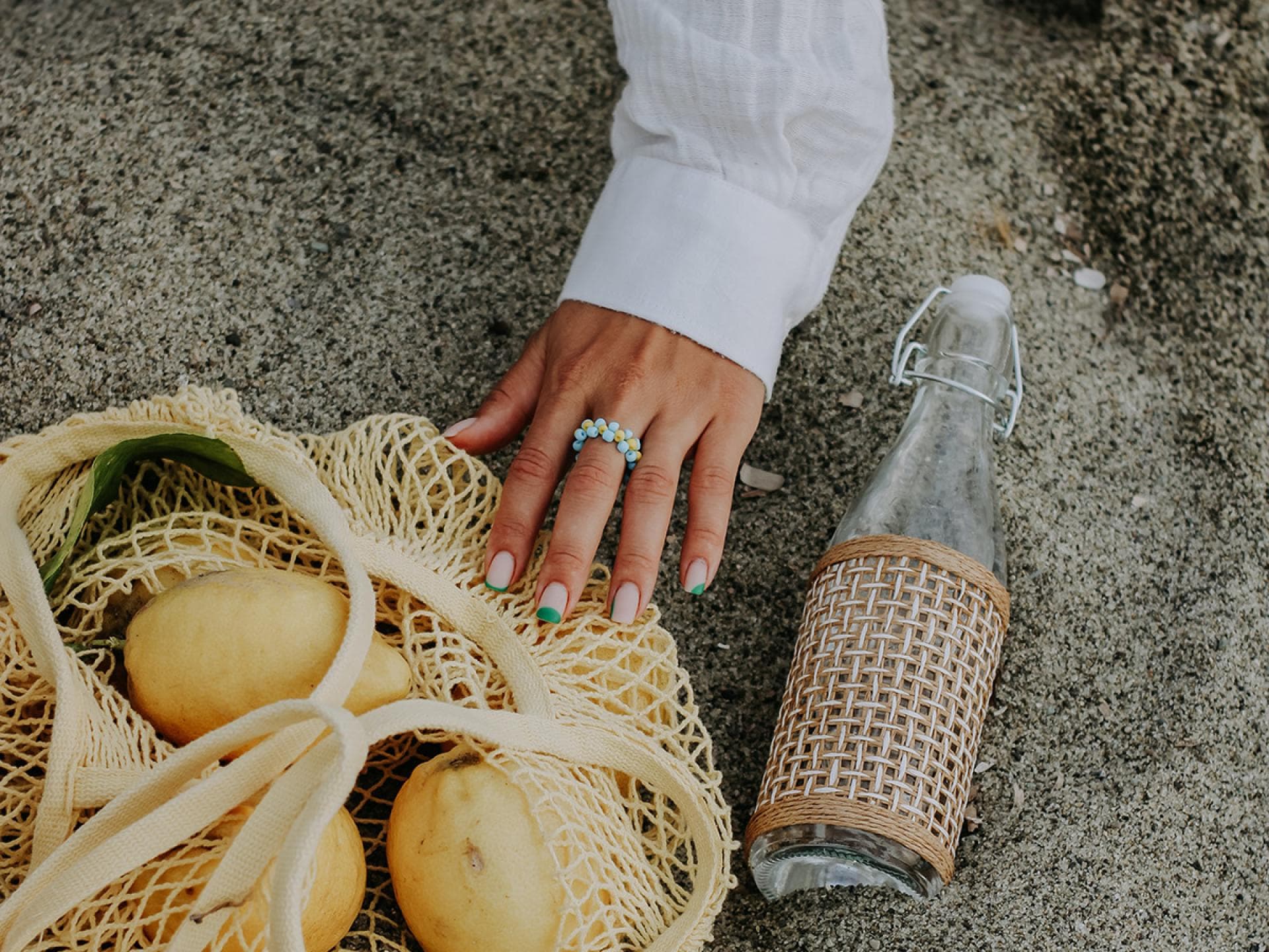 Ring am Finger und Zitrone am Strand