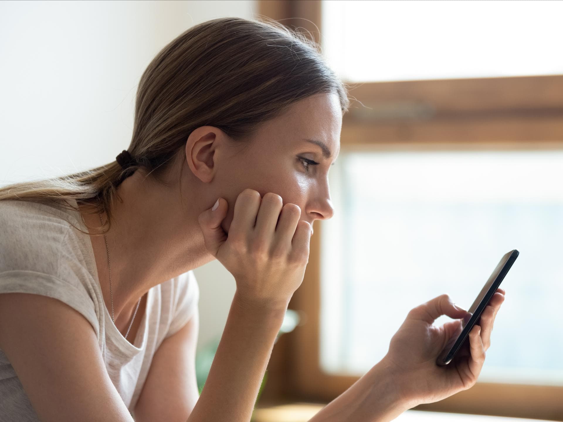Frau schaut traurig auf Handy
